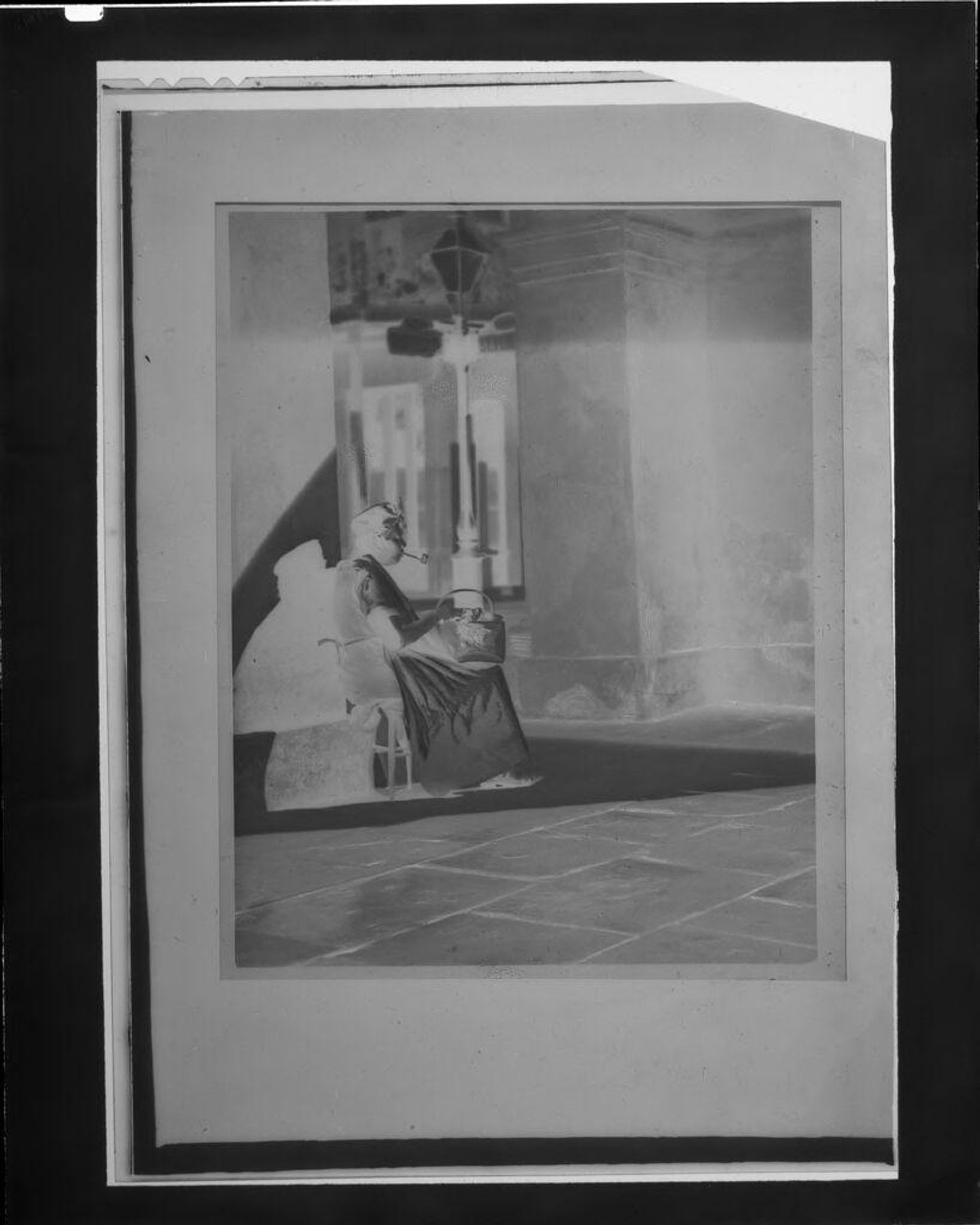 Untitled (woman with pipe sitting on stoop) by C. Bennette Moore