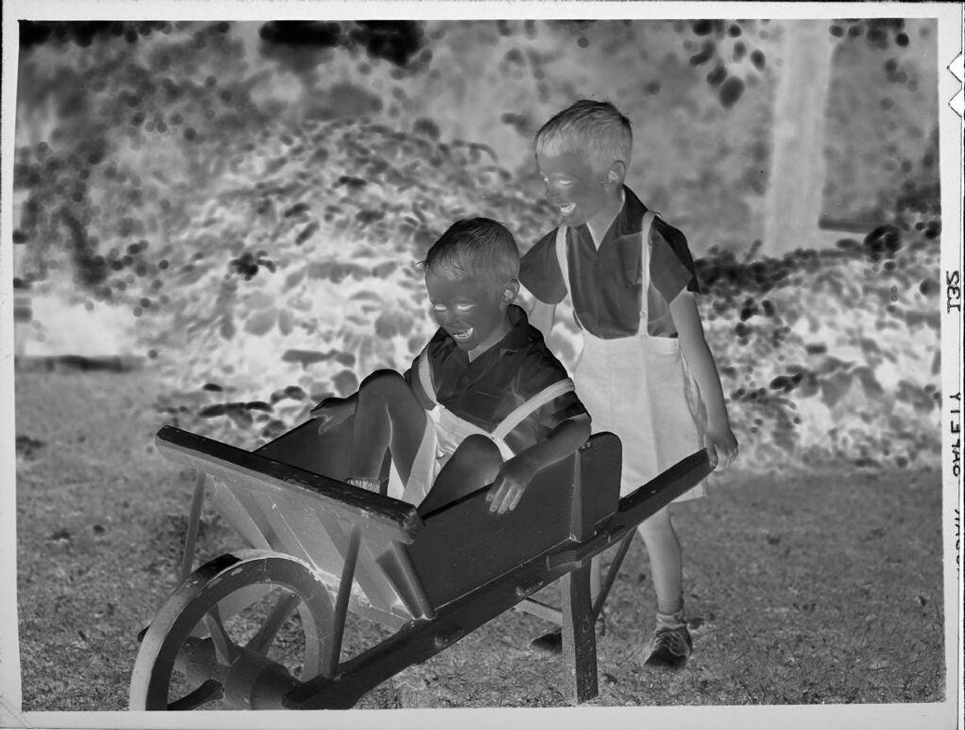 Untitled (two boys playing in wheelbarrow) by Lucian and Mary Brown