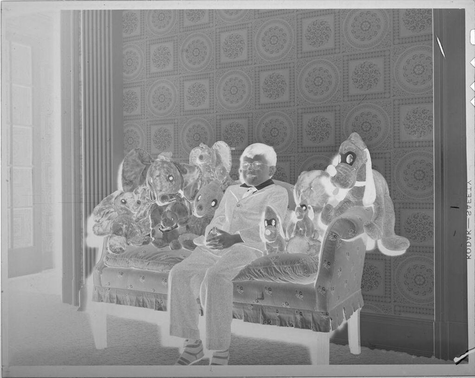 Untitled (boy on couch with stuffed animals) by Lucian and Mary Brown