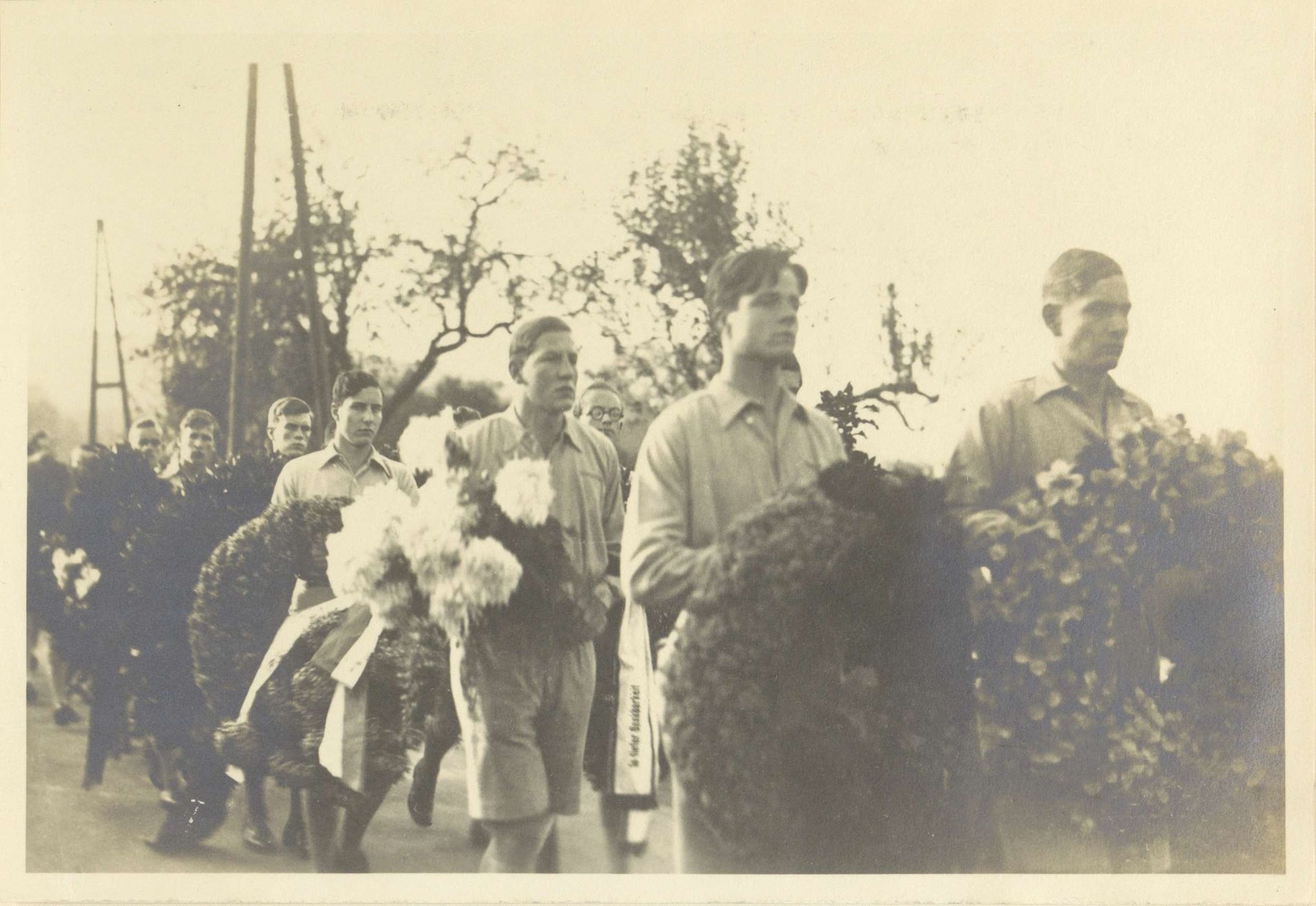 Jongemannen dragen bloemstukken bij de uitvaart van Max van Baden by Anonymous