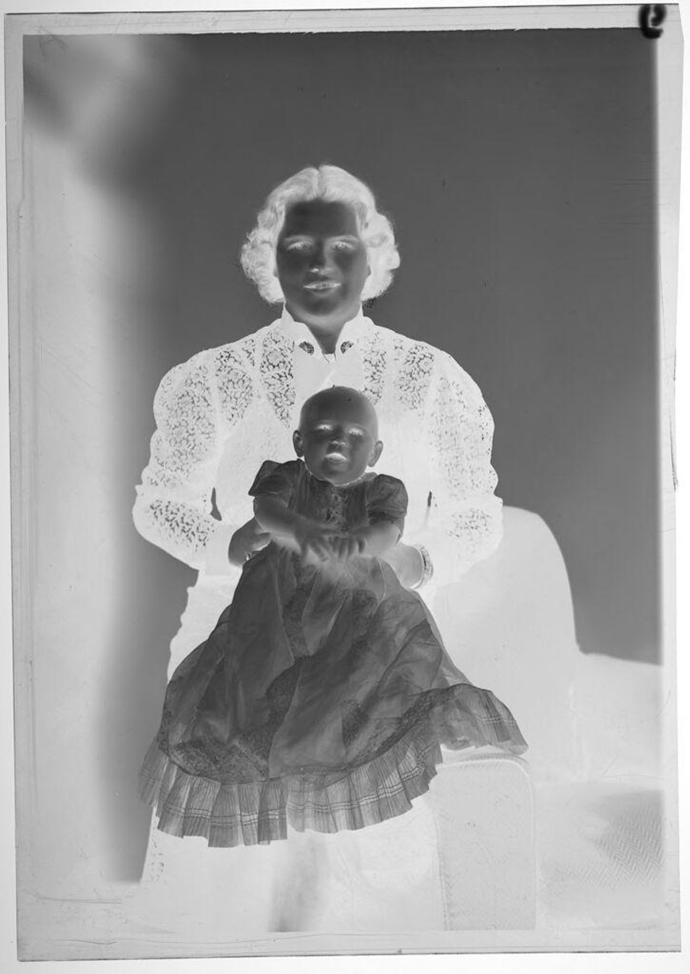 Untitled (studio portrait of woman in dark lacy dress with baby girl in long white dress) by Martin Schweig