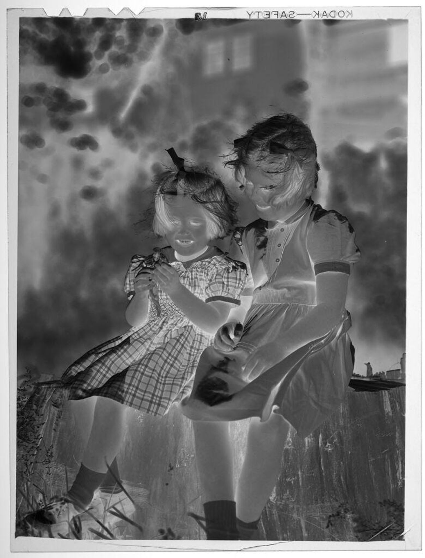 Untitled (two girls sitting on tree stump) by Lucian and Mary Brown