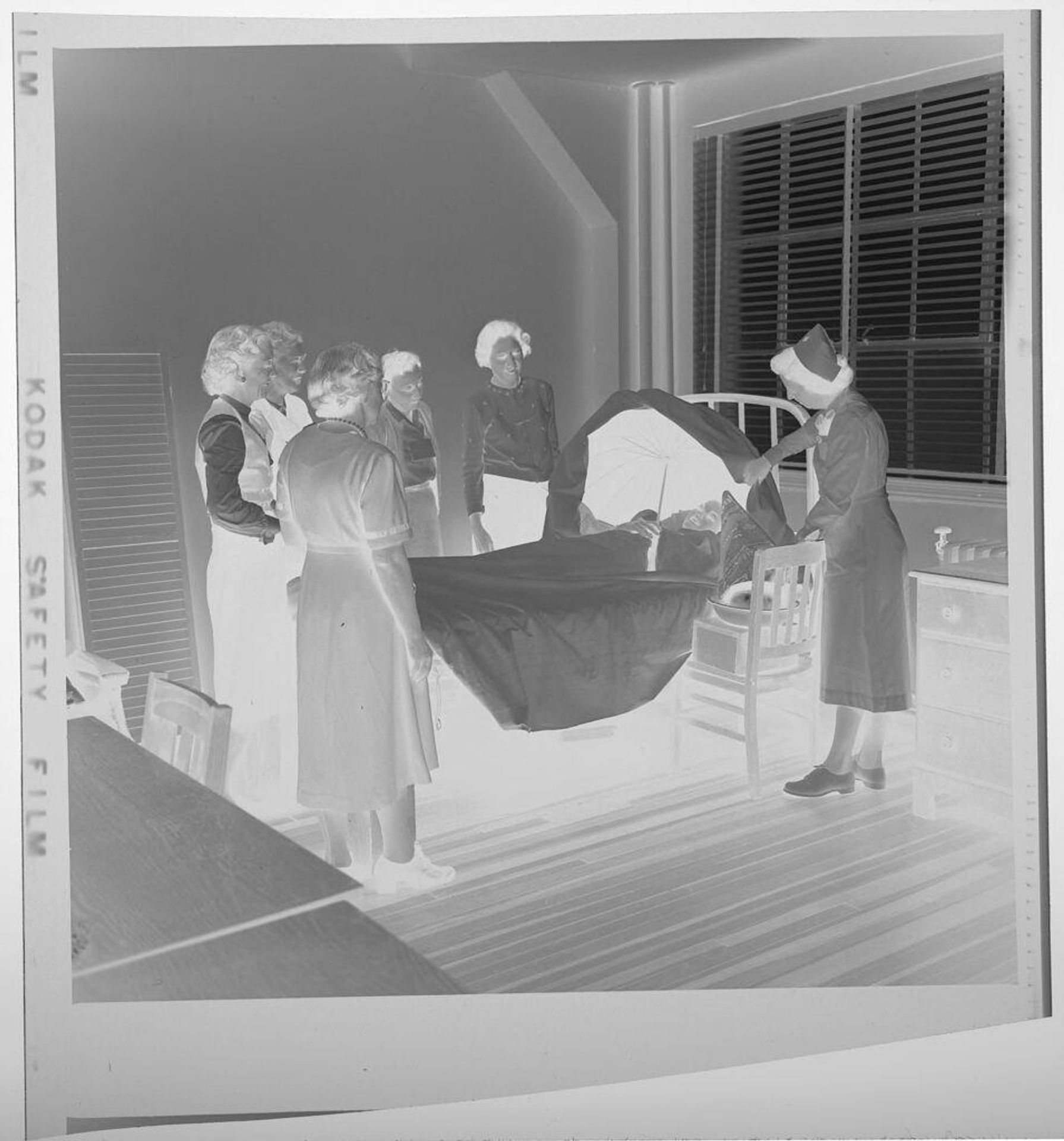 Untitled (women gathered around hospital bed) by Jack Gould