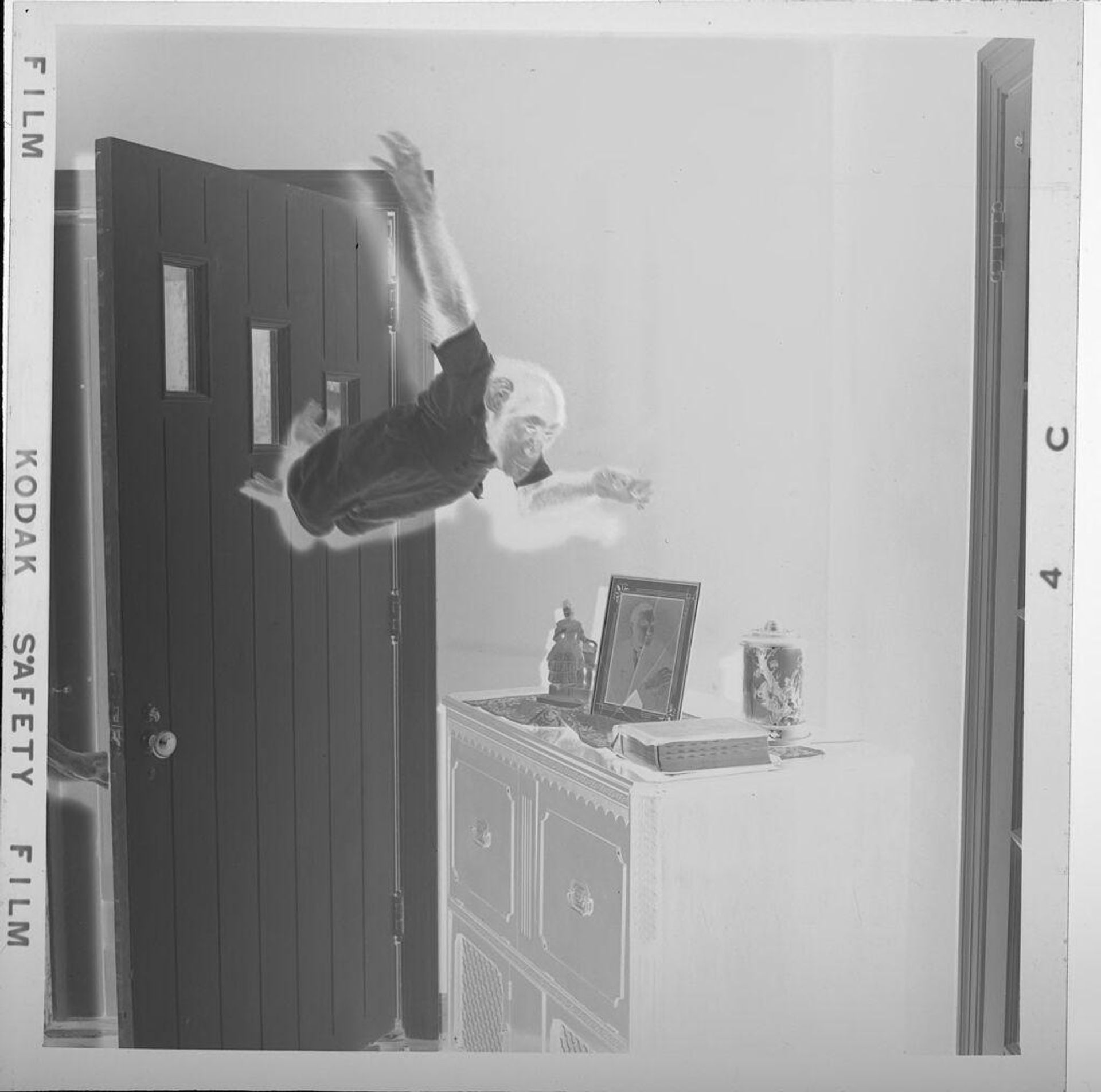 Untitled (monkey jumping from door inside house) by Jack Gould