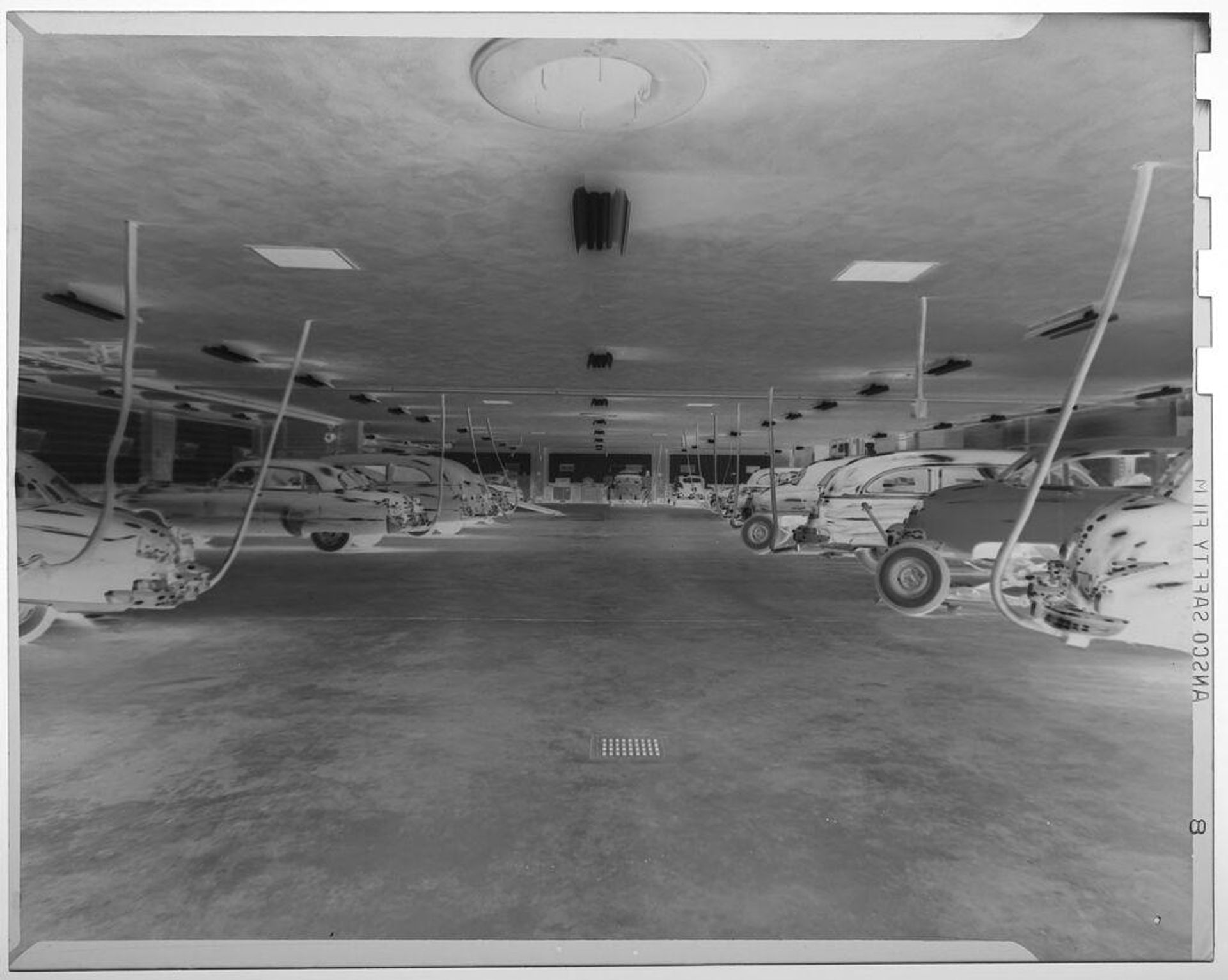 Untitled (card in garage with exhaust pipes conected to ceiling) by Jack Gould