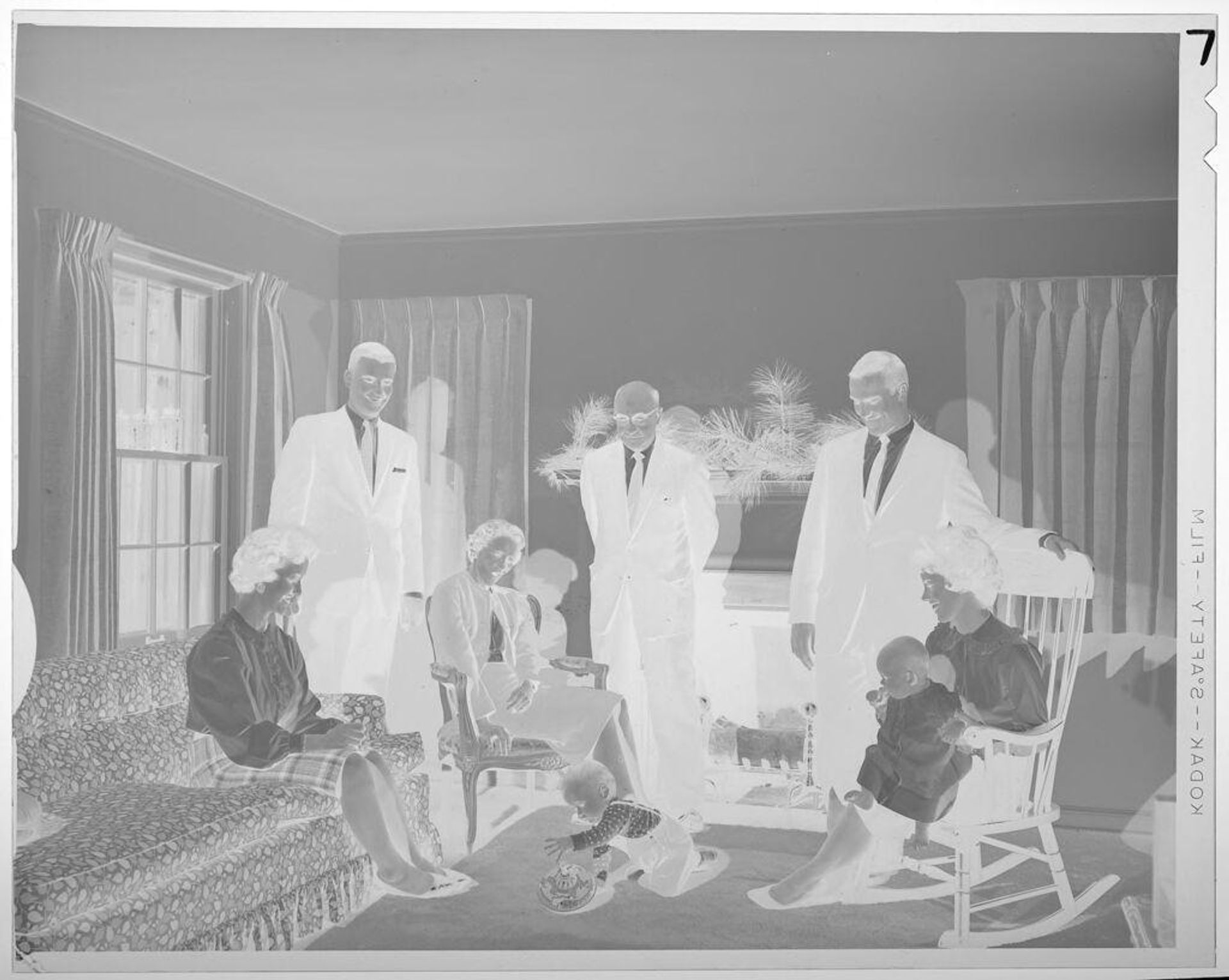 Untitled (men, women, and babies in living room) by Lucian and Mary Brown
