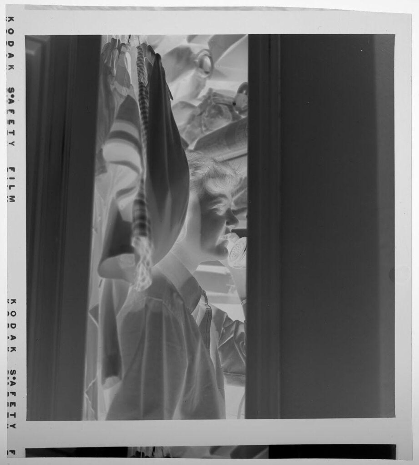 Untitled (girl talking on telephone seen through narrow doorway) by Jack Gould