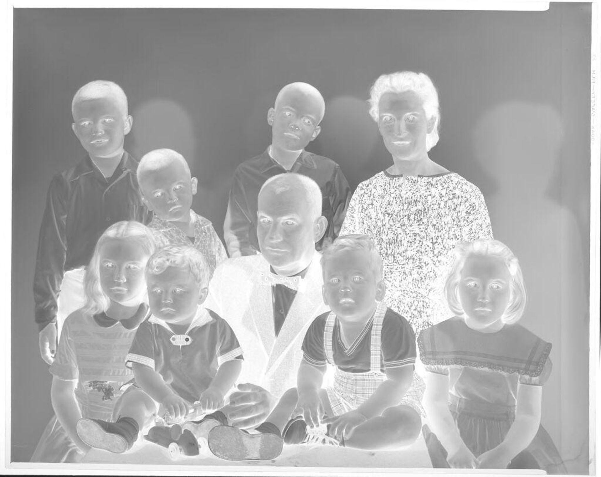 Untitled (family portrait, seven children, all looking at camera) by John Deusing