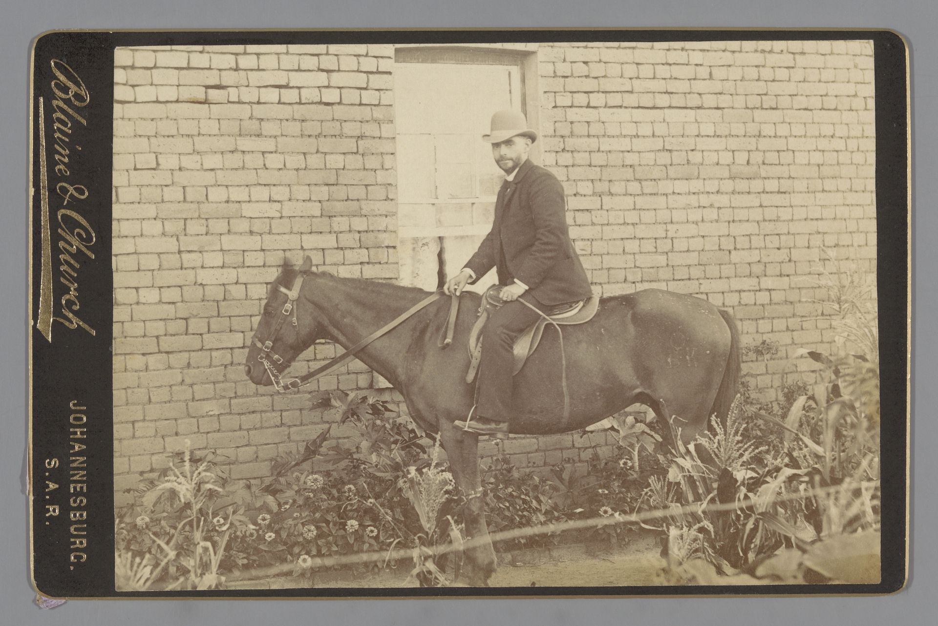 Portret van een onbekende man op een paard voor een woning by Blaine & Church