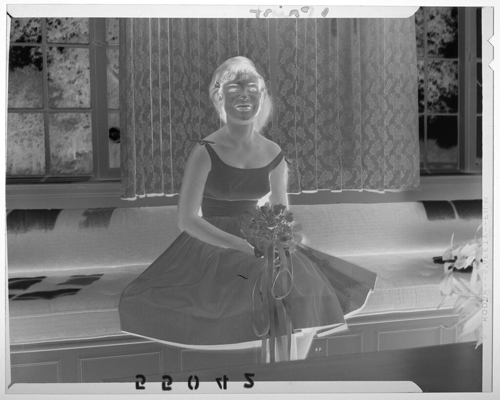 Untitled (young woman posed sitting on couch with flowers for coming out party) by Martin Schweig