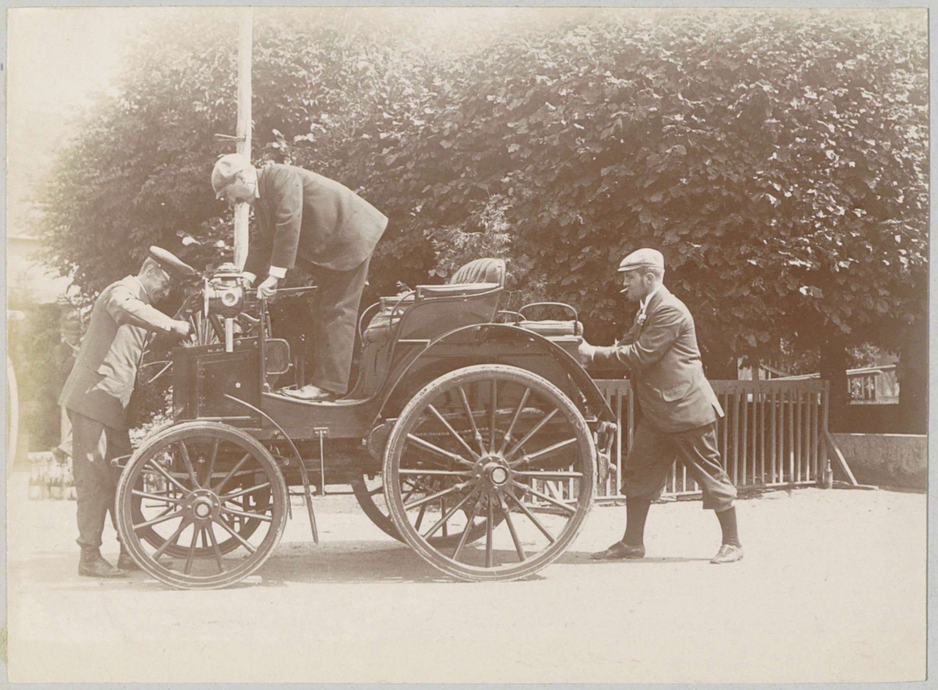 Drie mannen bij een automobiel in Varaville by Delizy