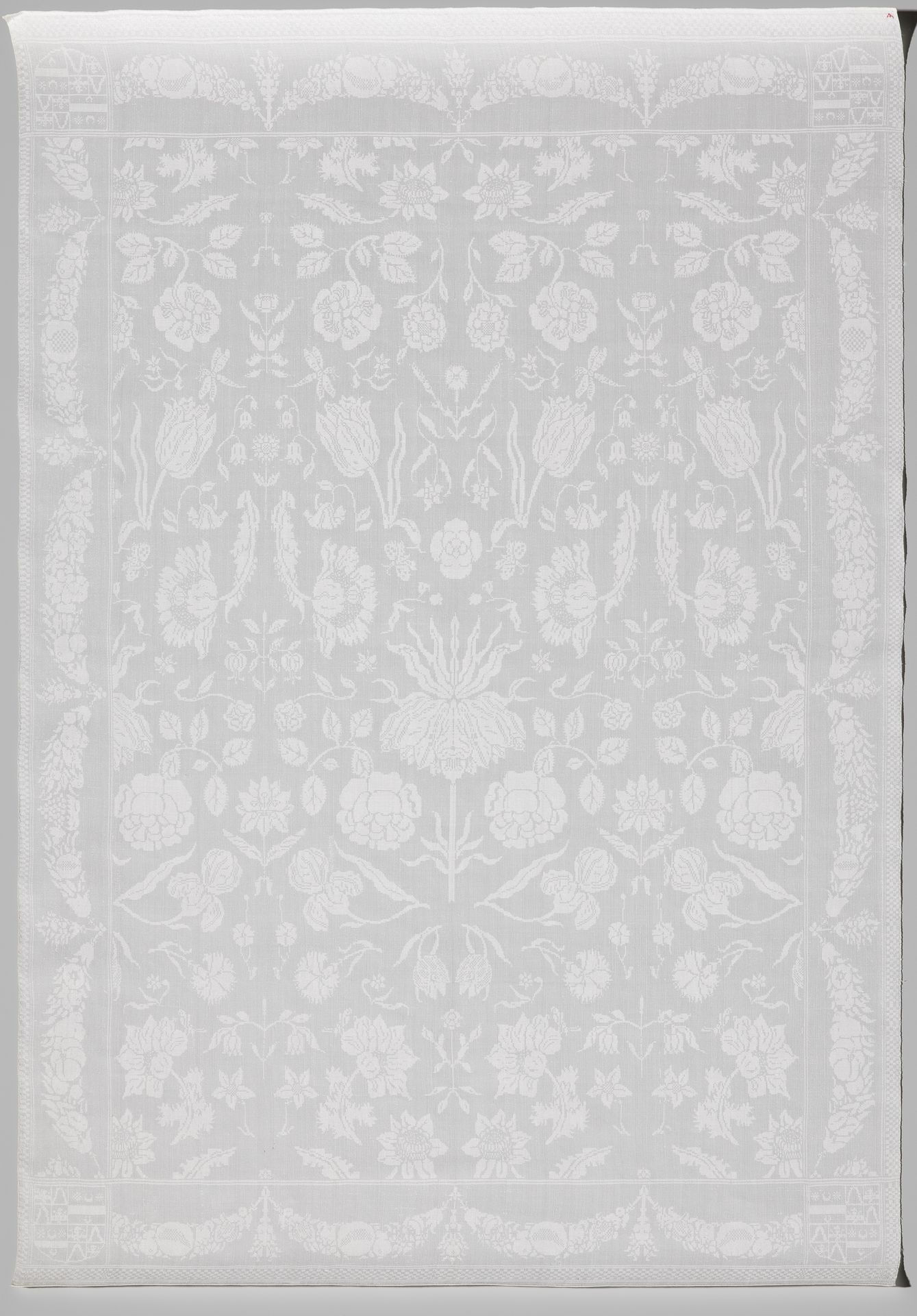 Servet van wit linnendamast met gestrooide bloemen en in de hoeken het gevierendeelde wapen Rijckaert-Bartolotti van den Heuvel by Anonymous