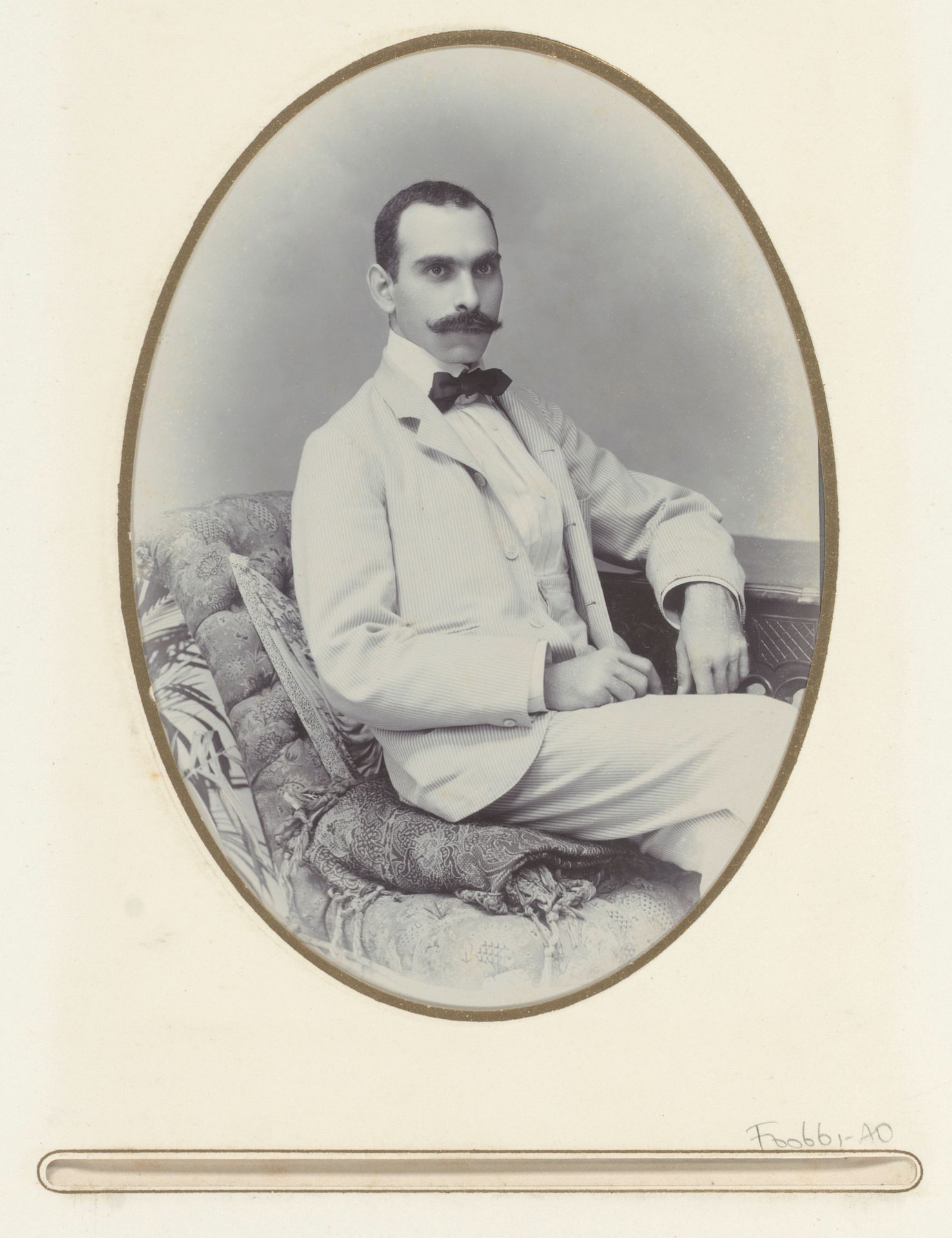 Portret van een man met snor, zittend op een divan bekleed met batik, aangeduid als Selei Edgar by Onnes Kurkdjian