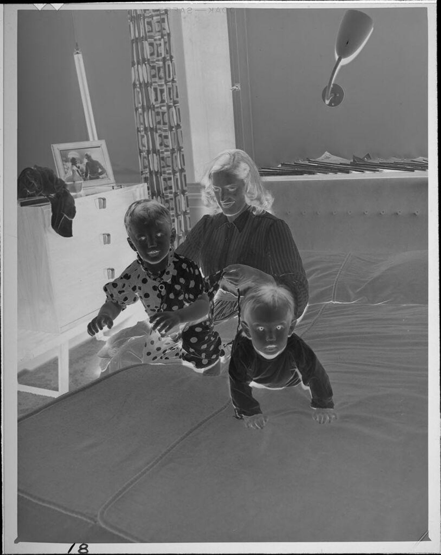 Untitled (woman and two babies on bed) by Lucian and Mary Brown