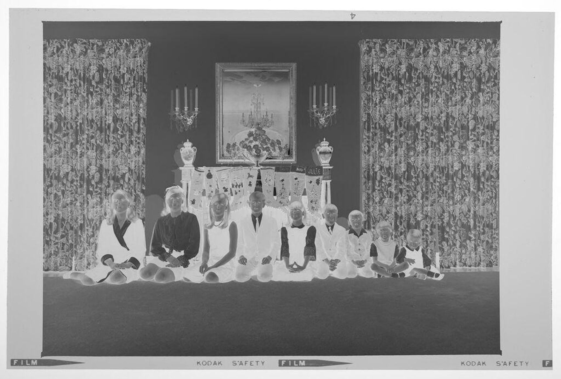 Untitled (nine children posed sitting in front of fireplace decorated with stockings) by Martin Schweig