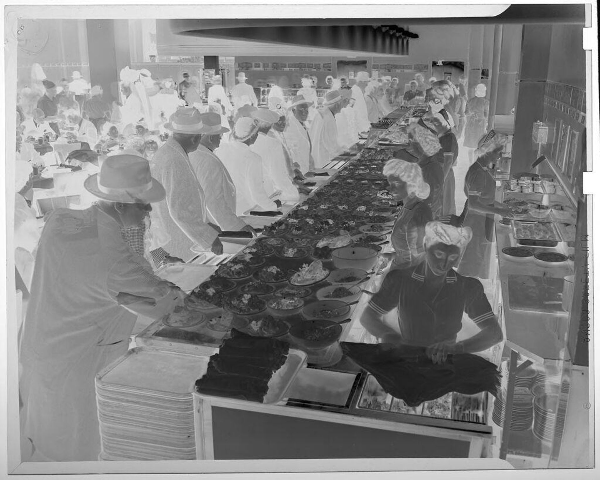 Untitled (long line of people inside cafeteria, waiting in line for food) by Jack Gould