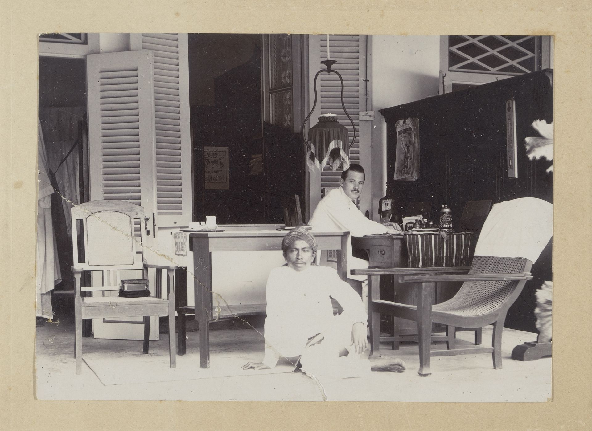 Europese en Indonesische mannen op een veranda in Nederlands-Indië by Gah Hien