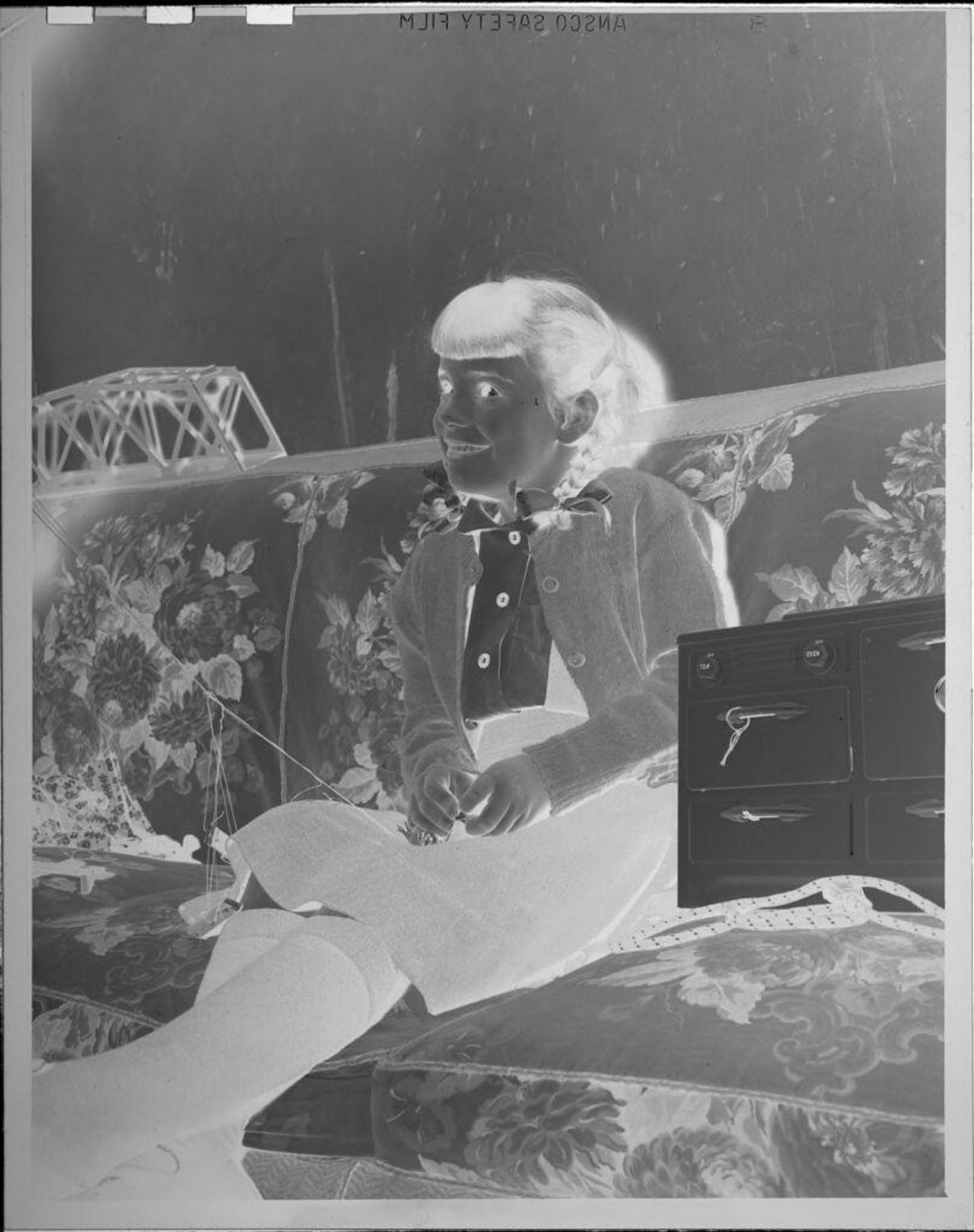 Untitled (girl sitting on couch) by Lucian and Mary Brown