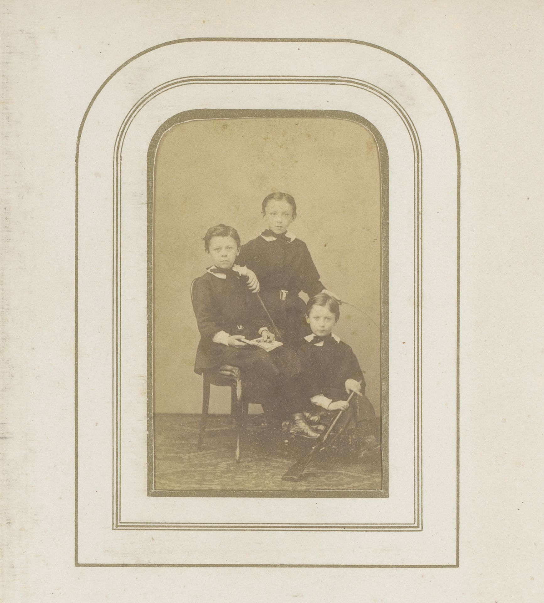 Groepsportret van drie kinderen met geweer, stok en hoepel by Jules (fotograaf) Géruzet