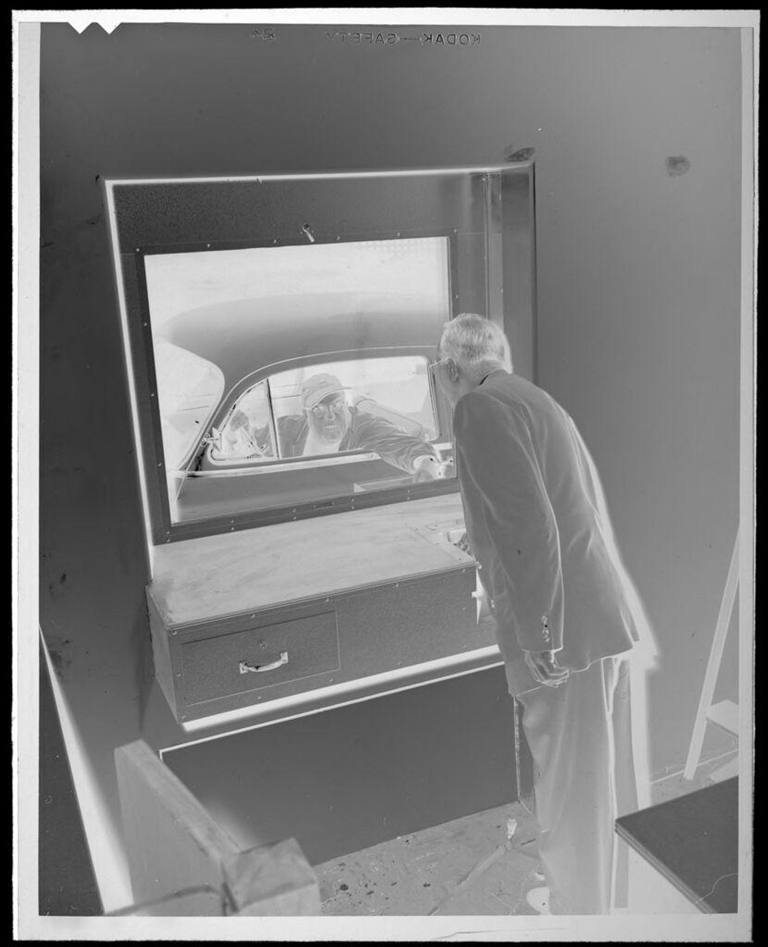 Untitled (man looking out drive-in wondow) by Lucian and Mary Brown
