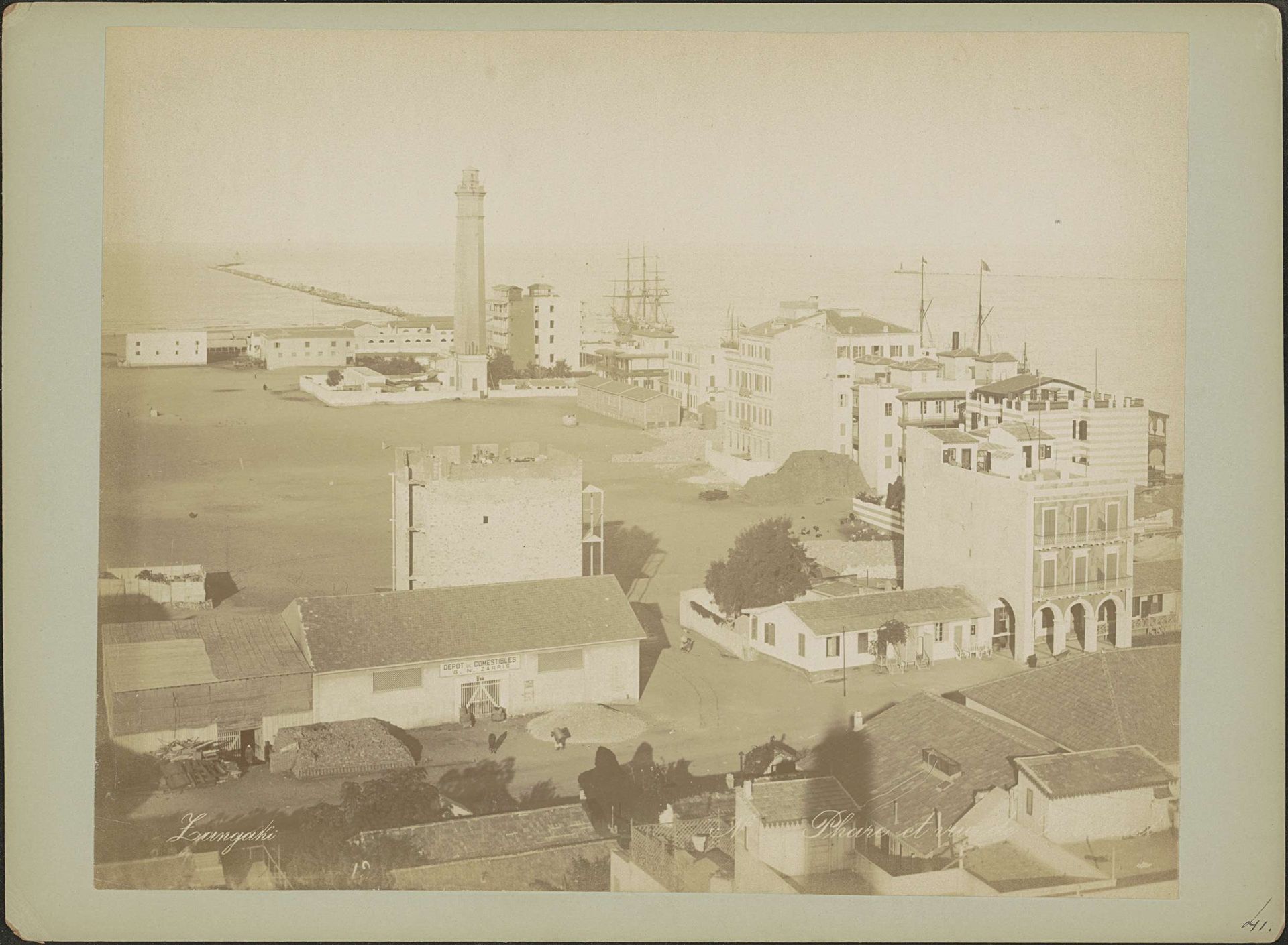 Gezicht op gebouwen, de vuurtoren en de ingang van het Suezkanaal bij Port Said by C. & G. Zangaki