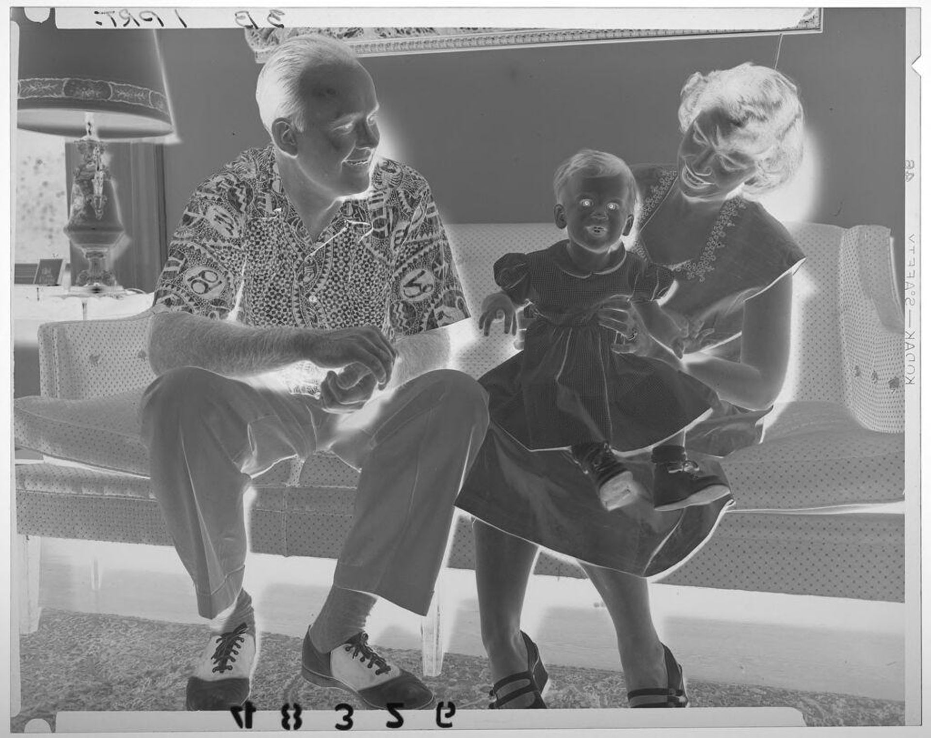 Untitled (man and woman posed sitting on couch with baby girl) by Martin Schweig