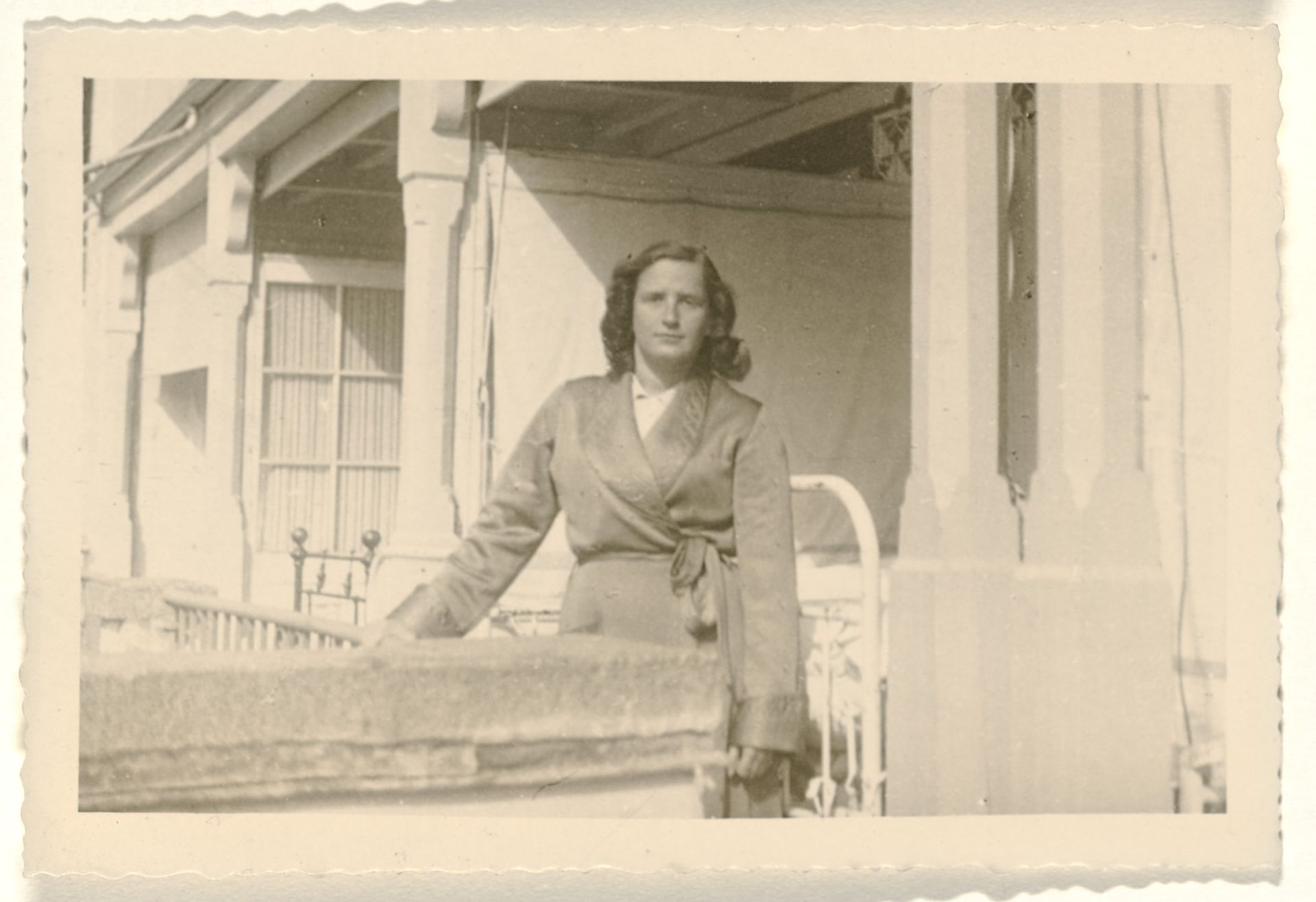 Isabel Wachenheimer in kamerjas staand voor de toegang tot een openlucht ziekenhuiskamer in het Joods sanatorium Etania in Davos, april 1946 by Anonymous