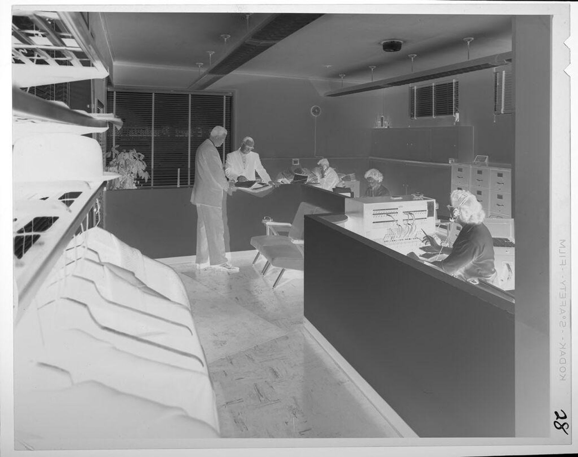 Untitled (office with receptionist and coatrack) by Lucian and Mary Brown