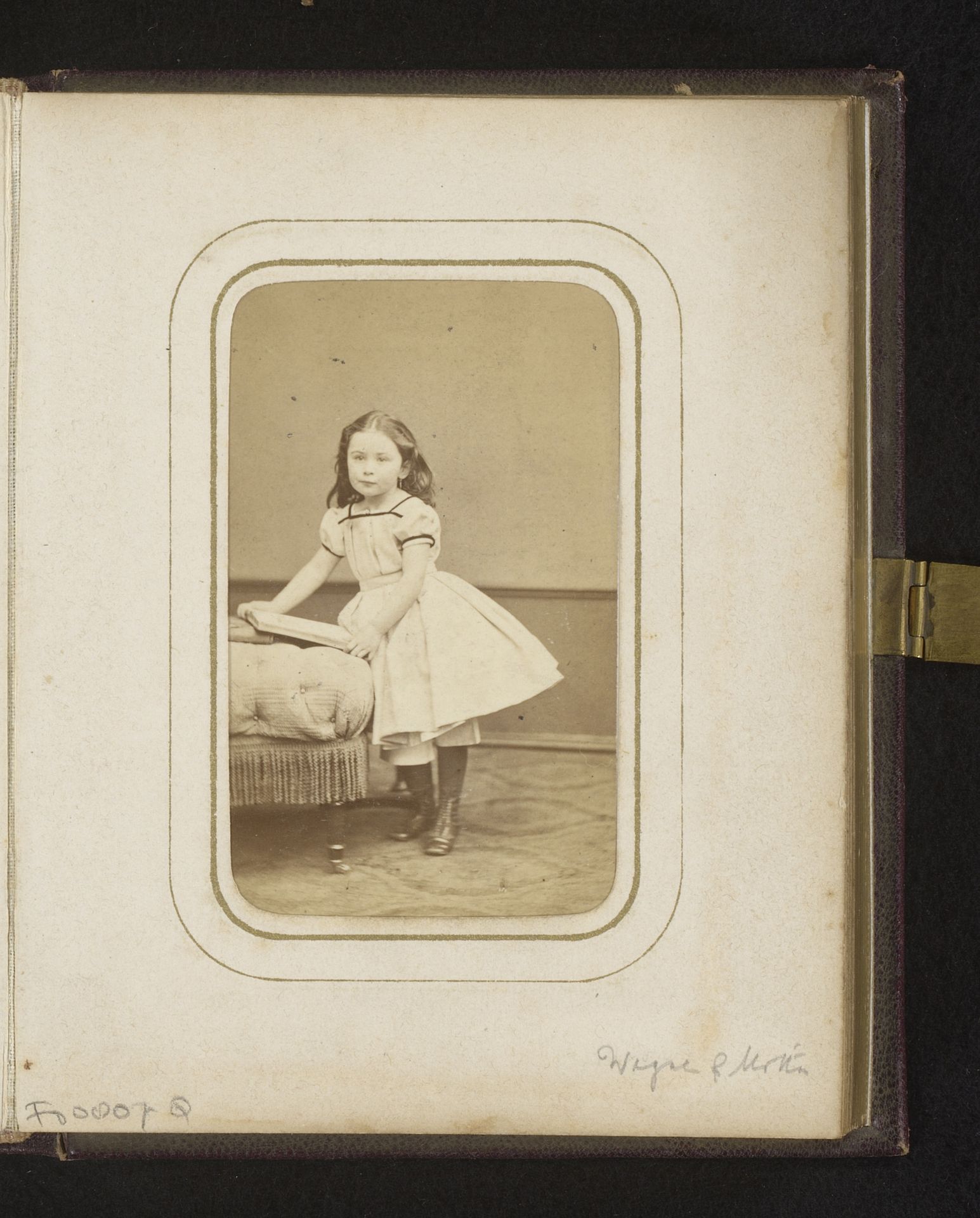 Portret van een meisje staand bij een divan met boeken, aangeduid als Elise by Wegner & Mottu