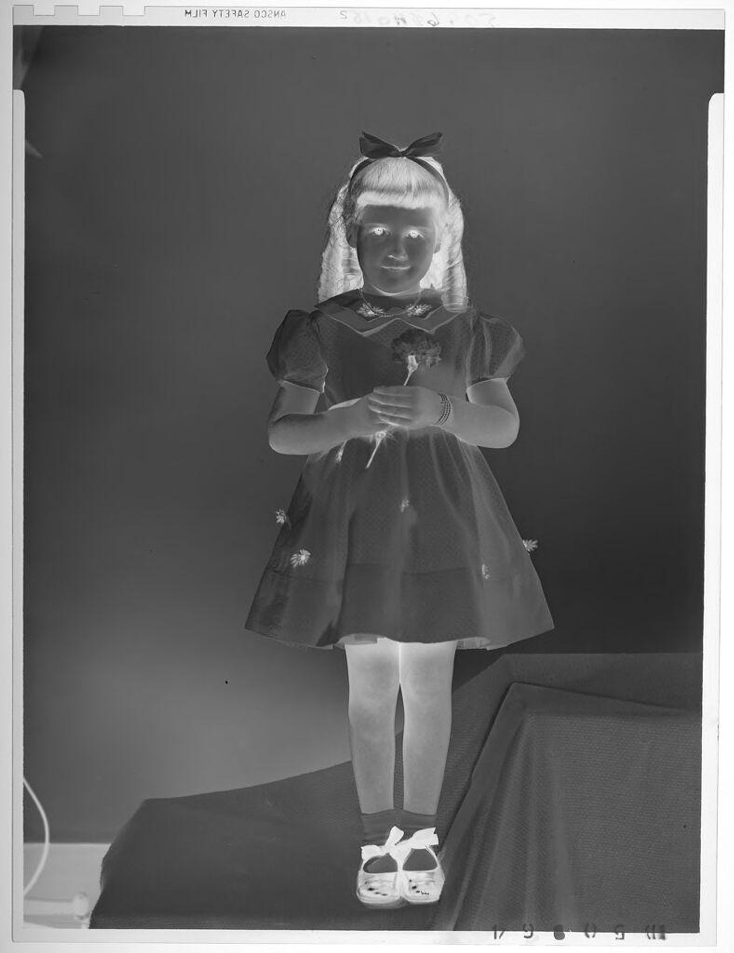 Untitled (portrait of girl with ringlets in dress, standing, holding carnation) by Paul Gittings