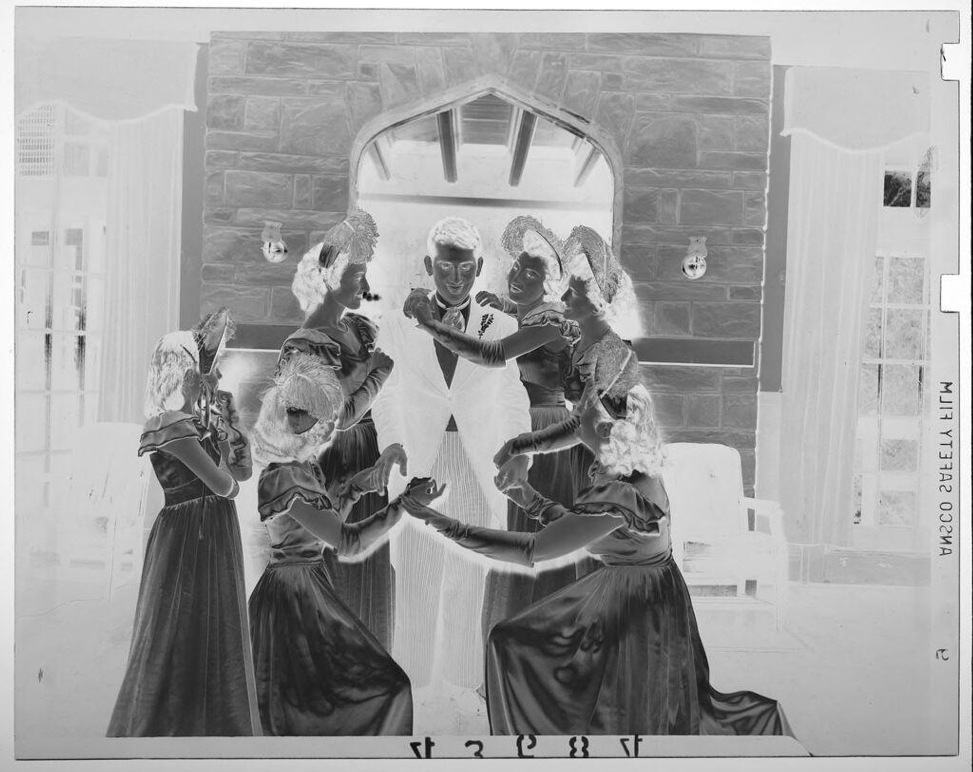 Untitled (five wedding bridesmaids in feather hats encircling groom) by Martin Schweig