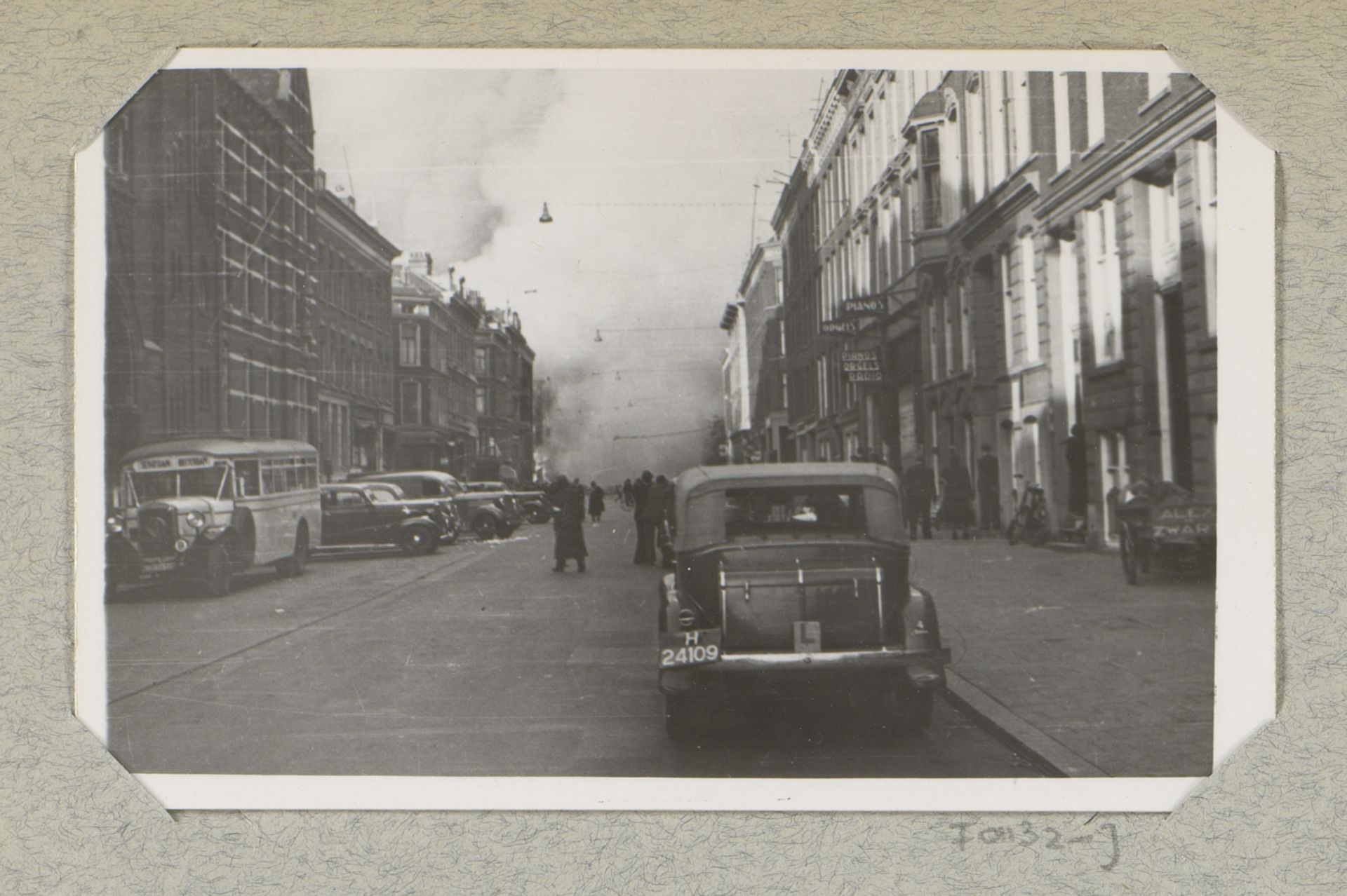 Personen kijken naar rookwolken in de Van Oldebarneveltstraat te Rotterdam by J. Nolte