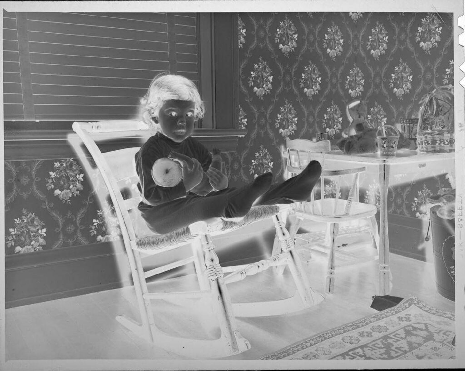 Untitled (girl on rocking chair holding doll) by Lucian and Mary Brown