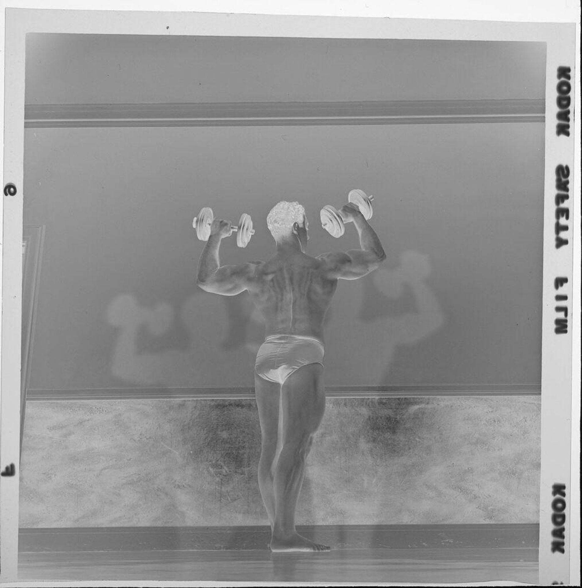 Untitled (man flexing muscles and holding barbells in "Mr. Universe" competition) by Jack Gould