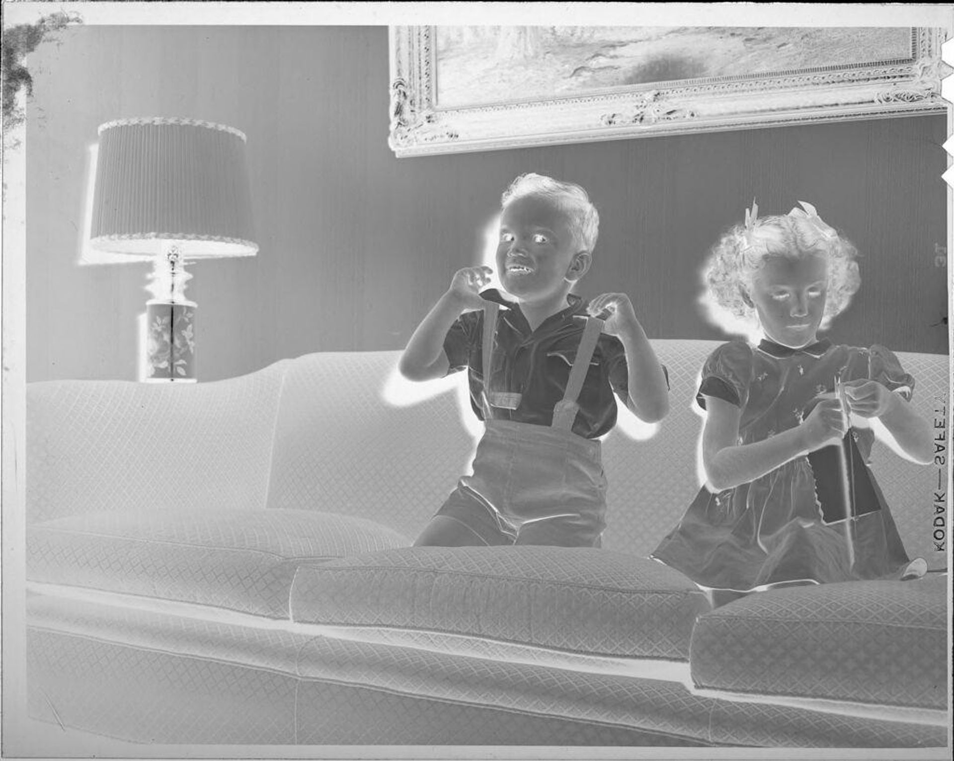 Untitled (boy and girl on couch) by Lucian and Mary Brown