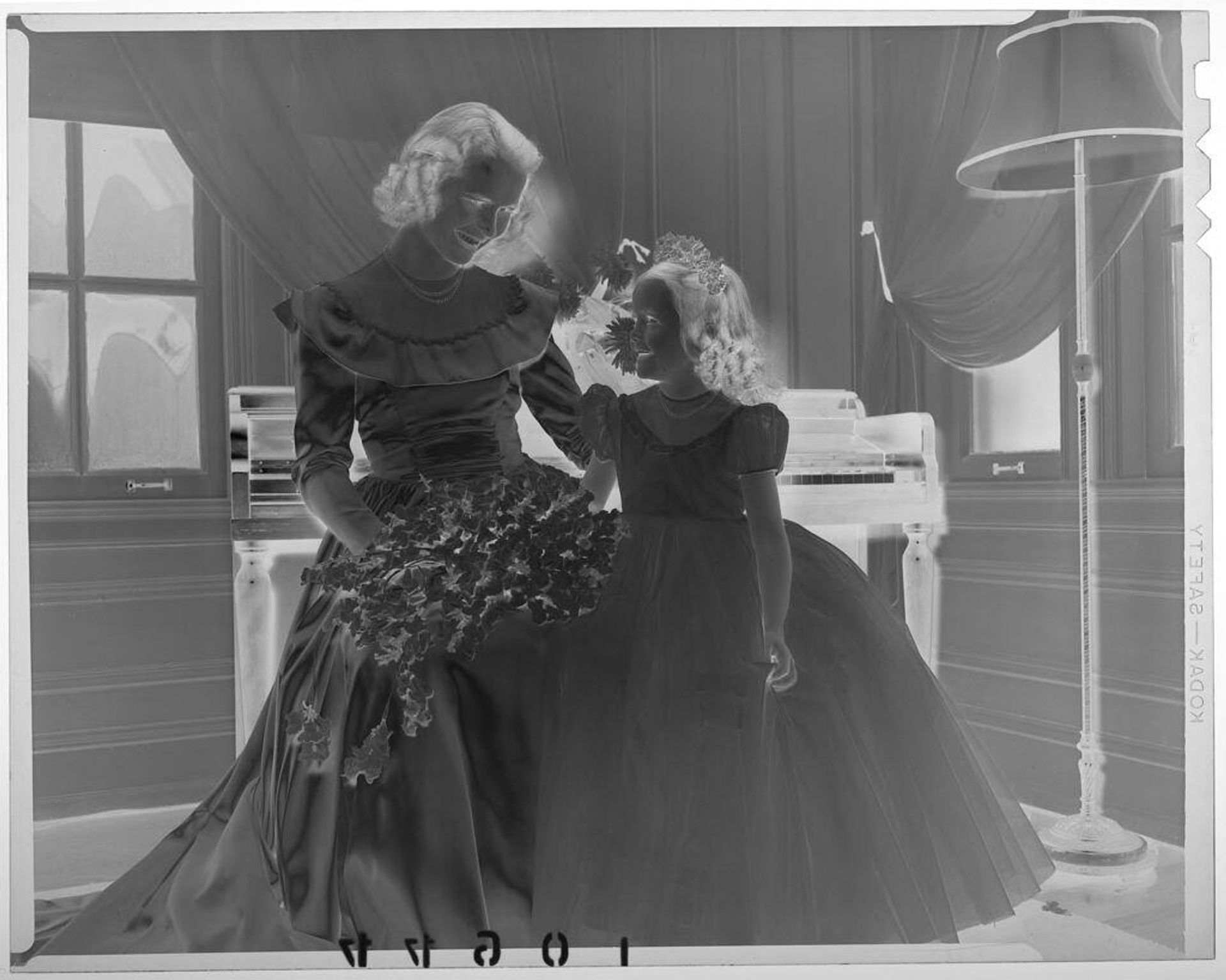 Untitled (bride sitting in front of piano posed smiling at young flower girl) by Martin Schweig