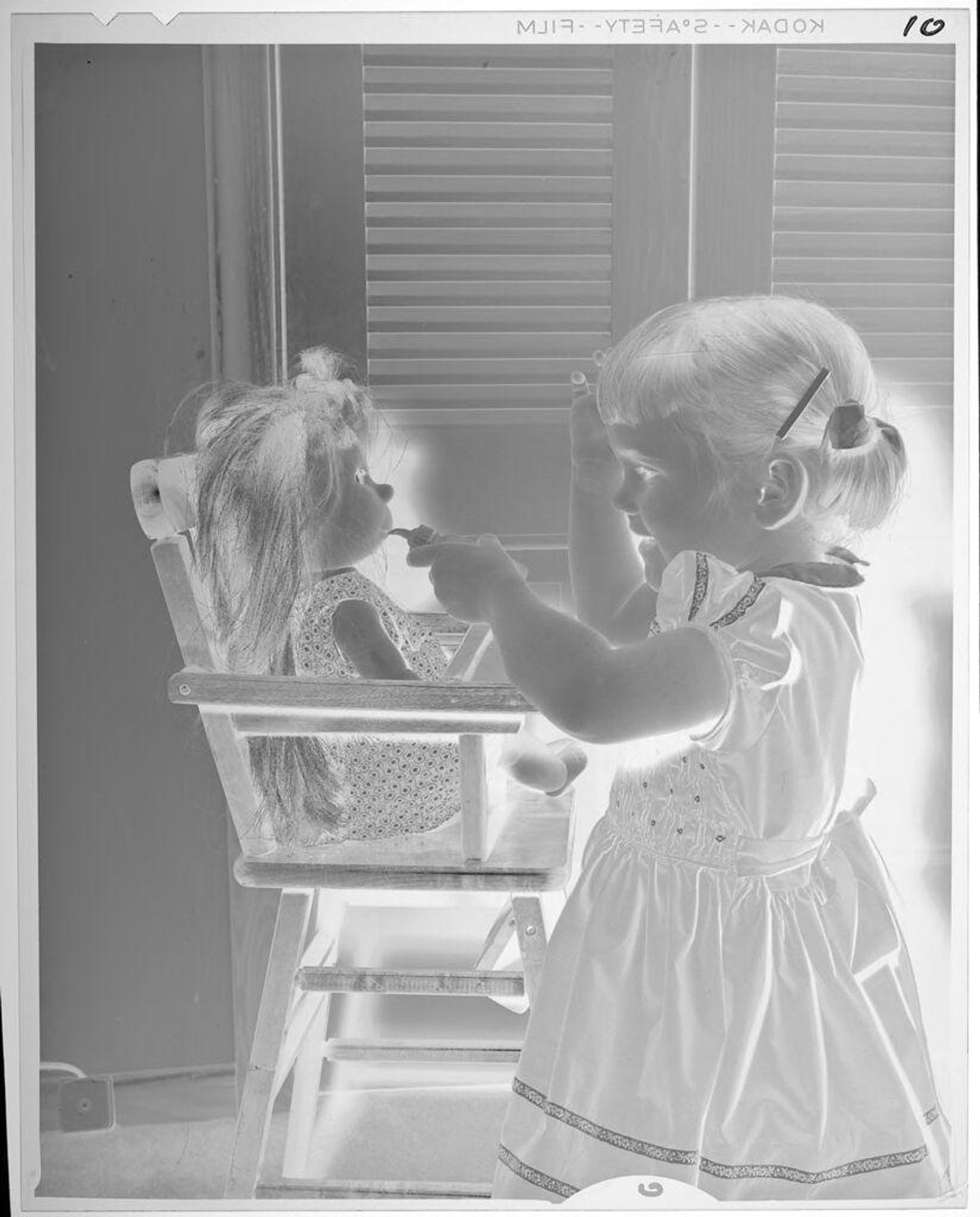 Untitled (girl pretending to feed doll) by Lucian and Mary Brown