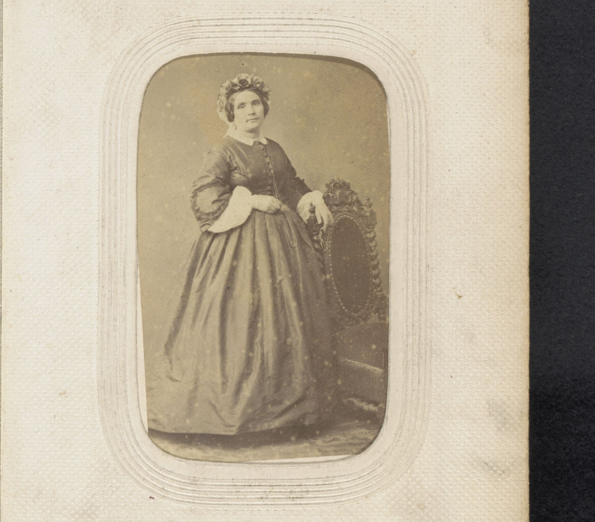 Portret van een staande vrouw met muts bij een stoel by Fourie