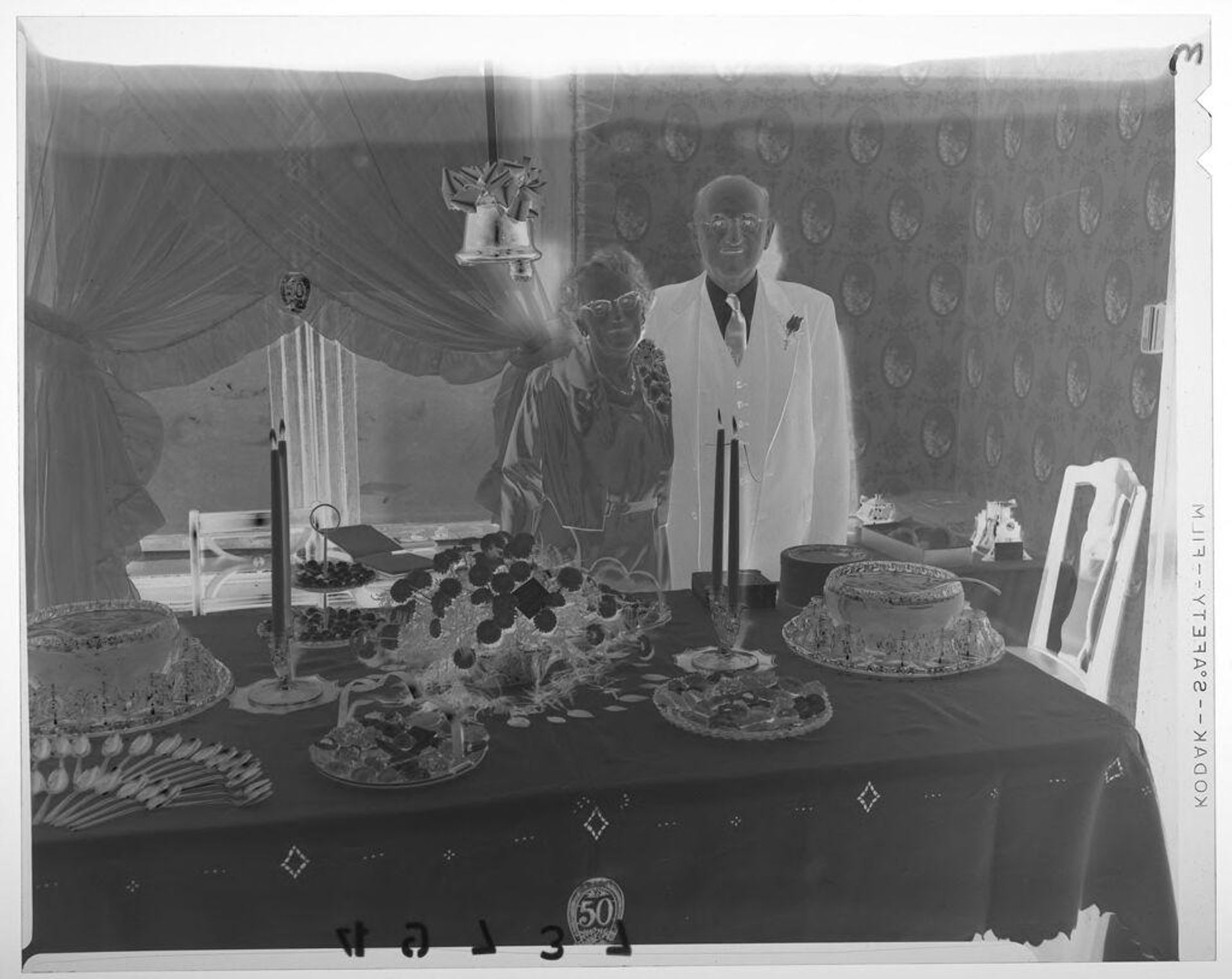Untitled (older couple posing by holiday food table in dining room) by Martin Schweig