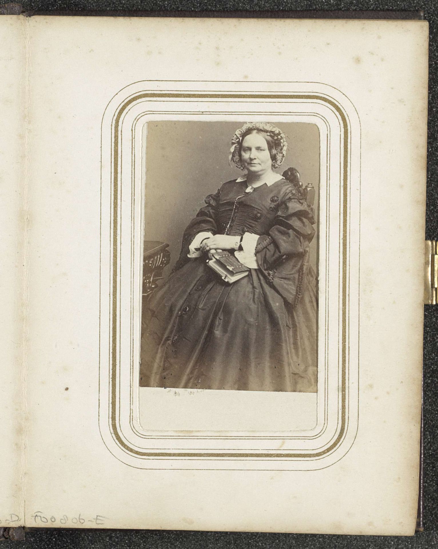 Portret van een zittende vrouw met een muts en (mogelijk) een fotoalbum in de hand by Matthijs Adolph Conen