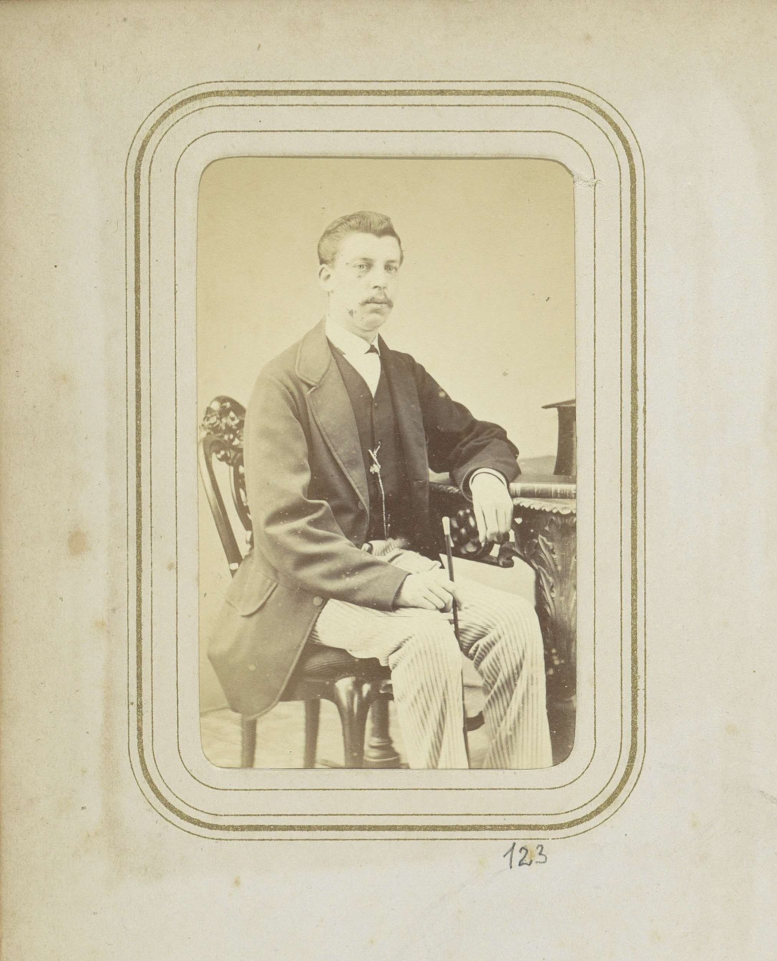 Portret van F.H.P. Ligtenberg in een lange jas met een gestreepte broek en een wandelstok by H. Jaeger & Co