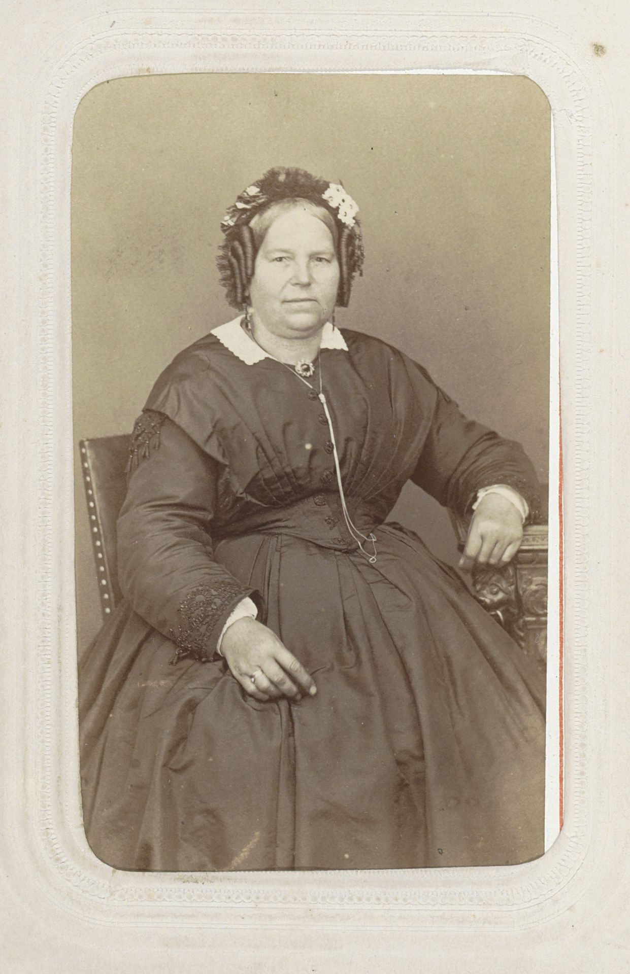Portret van een zittende vrouw met pijpenkrullen en een muts by Héliodore Dandoy