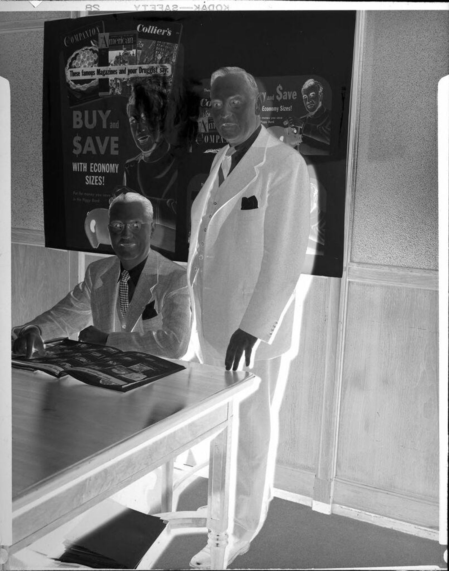 Untitled (two men in front of posters) by Peter James Studio