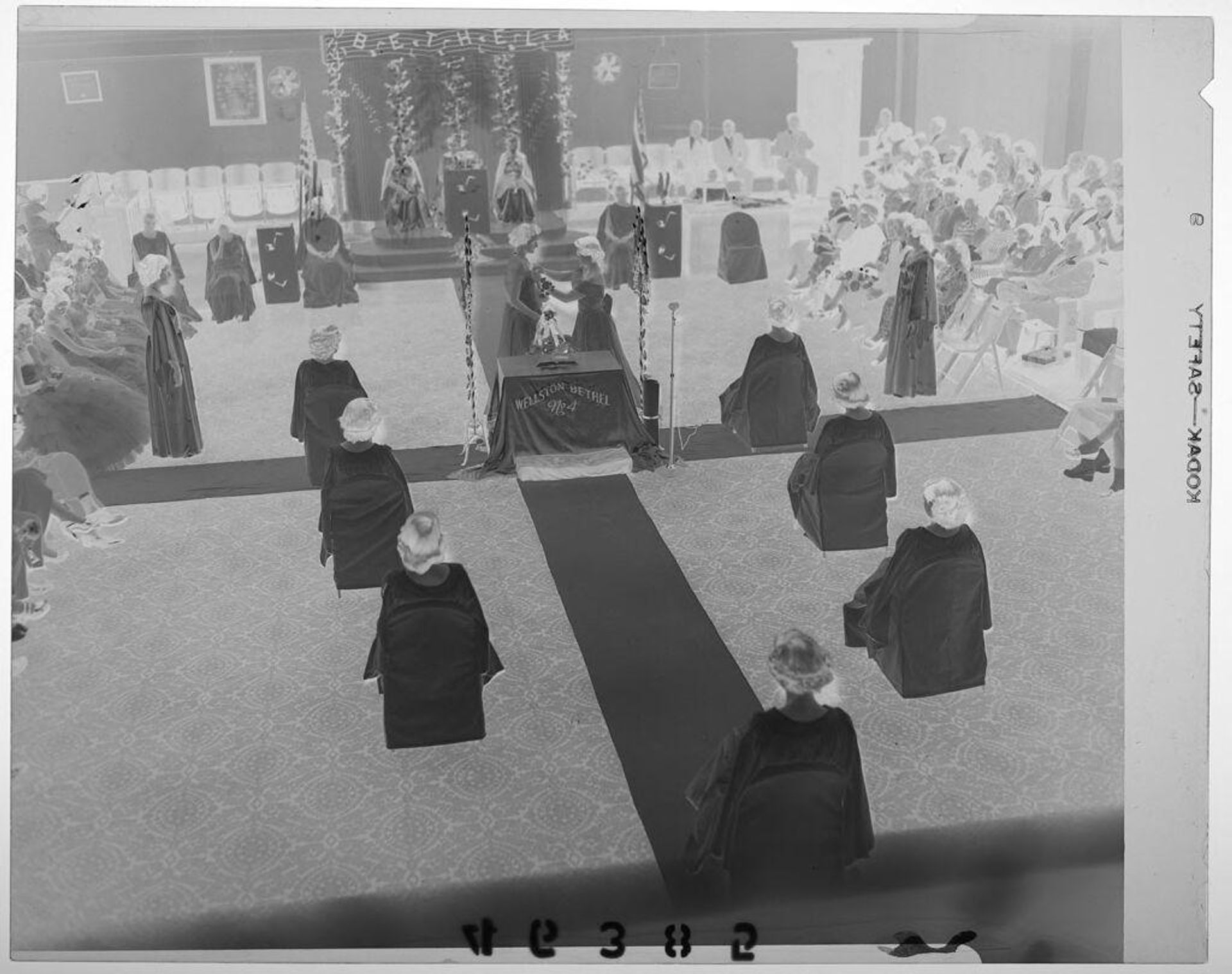 Untitled (elevated view of women seated in Masonic ceremony with audience watching) by Martin Schweig