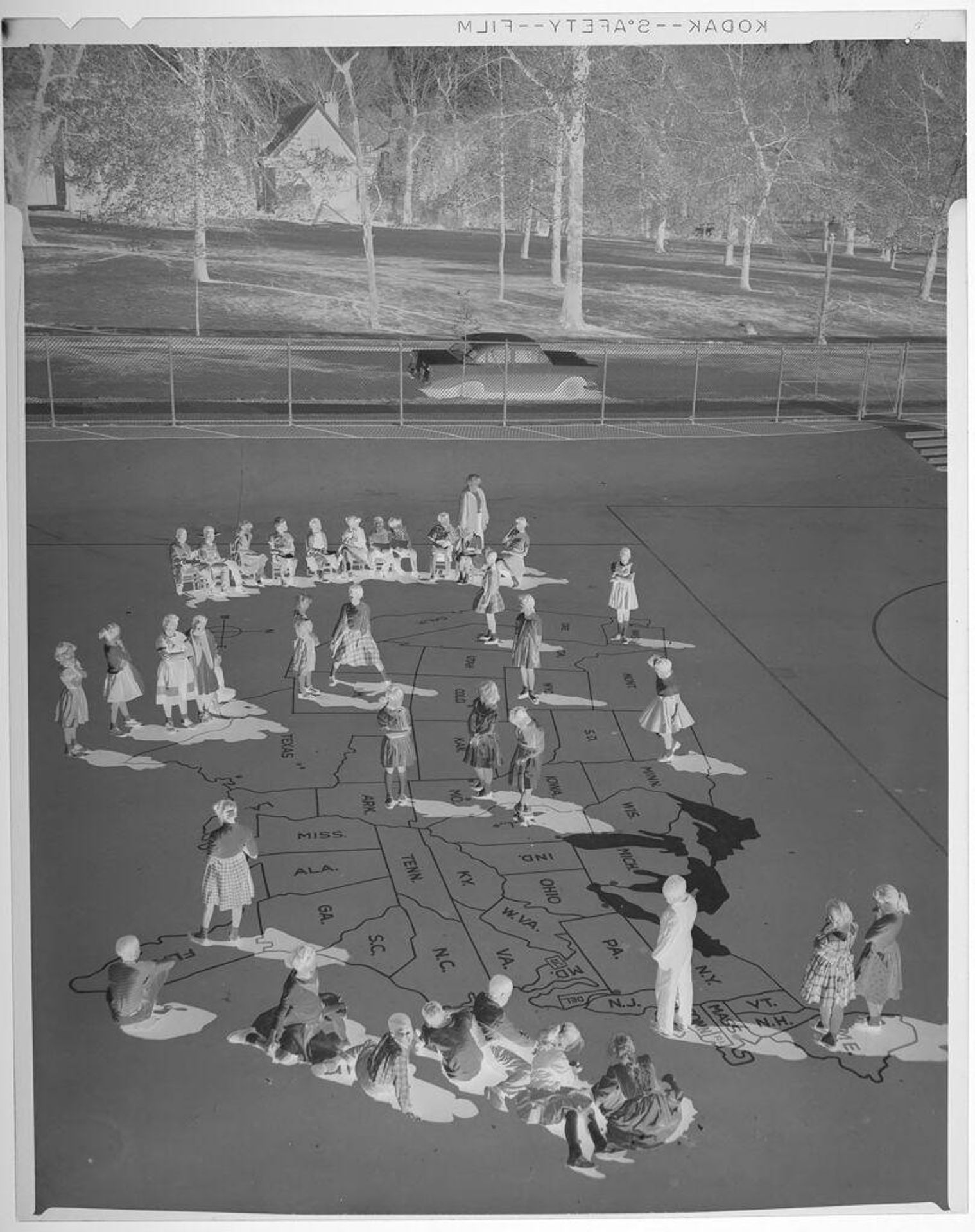 Untitled (children playing in outdoor lot on large map of United States) by Jack Gould