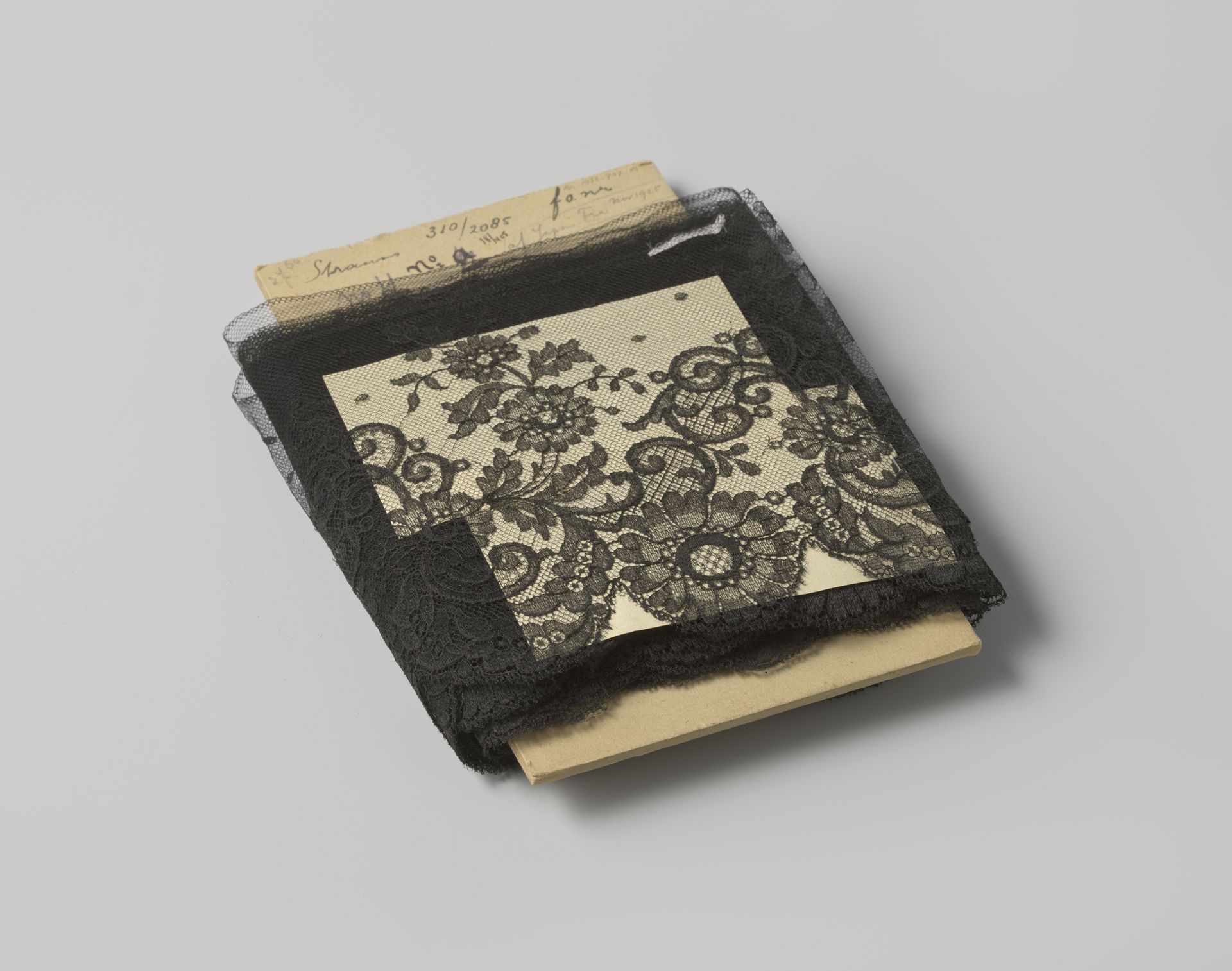 Strook zwarte machinale tule met schulpen aan één zijde en een ondulerend motief van bloemen en voluten by Gustav Schnitzler
