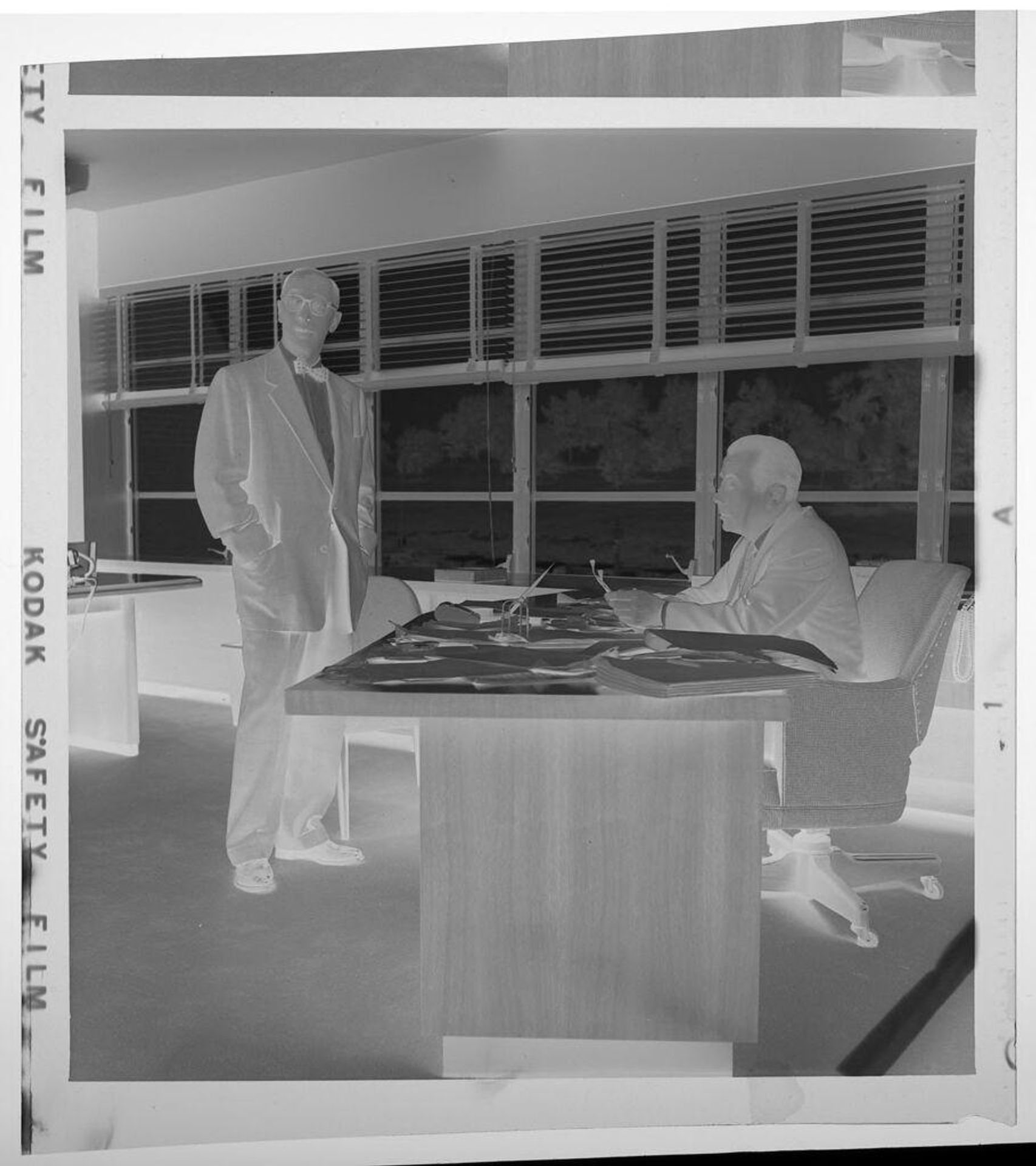 Untitled (two businessmen in office) by Jack Gould