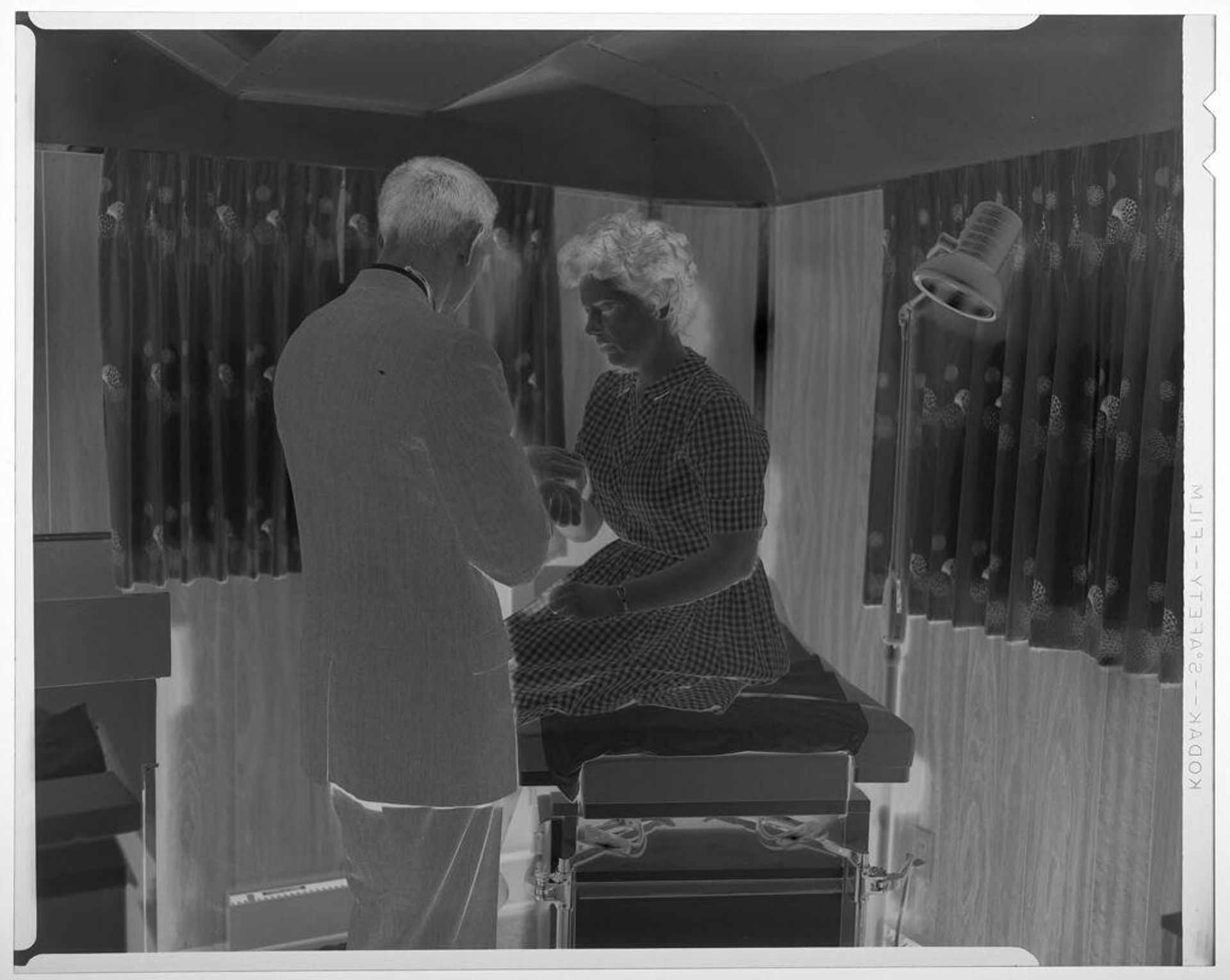 Untitled (man taking woman's pulse inside medical trailer) by Martin Schweig