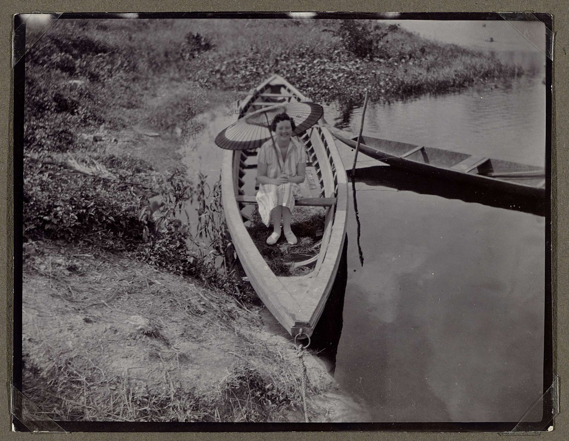 Edith Jetten met een parasol in een boot by Anonymous
