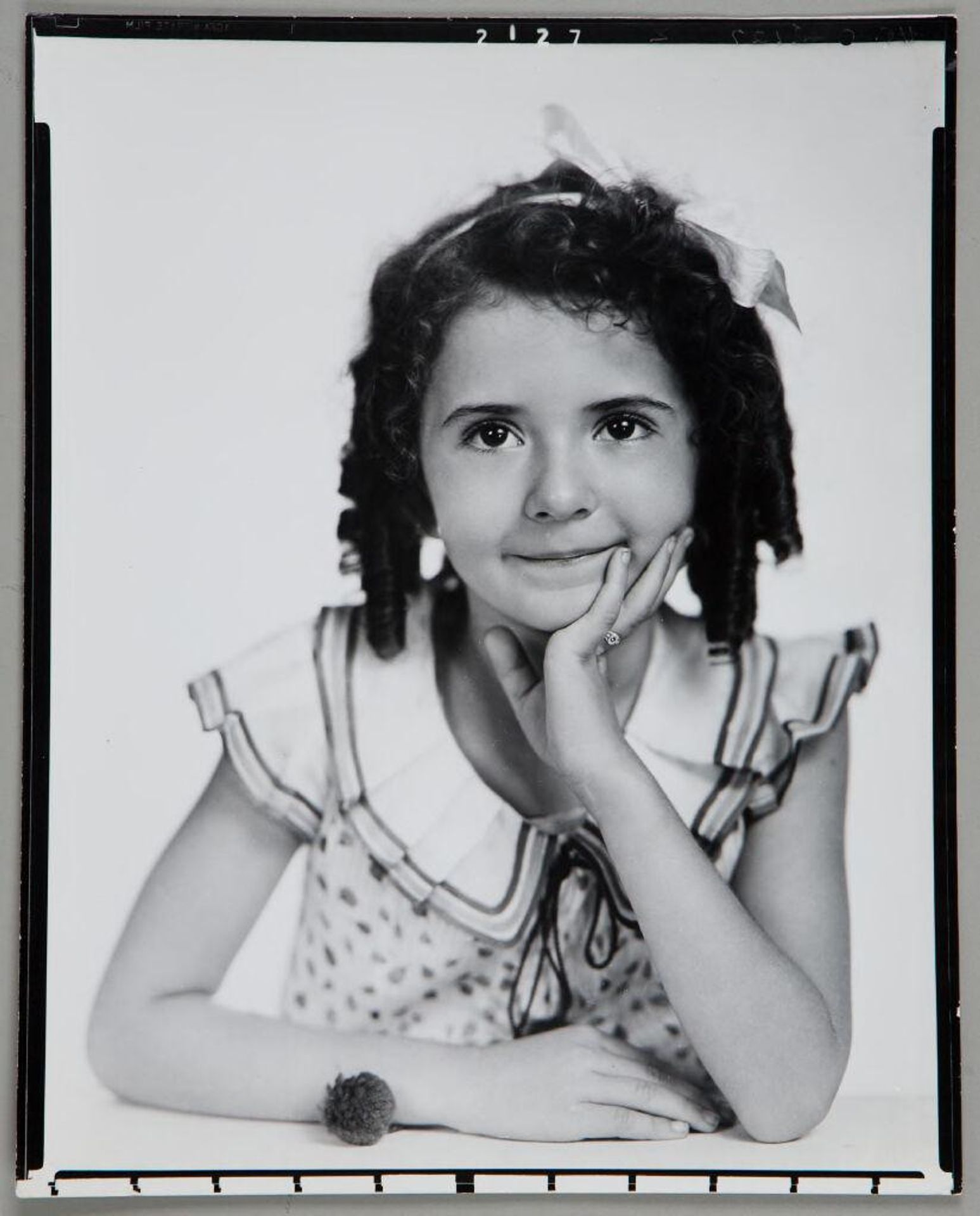Untitled (portrait of girl in dotted dress with ringlets, chin resting in hand) by Paul Gittings